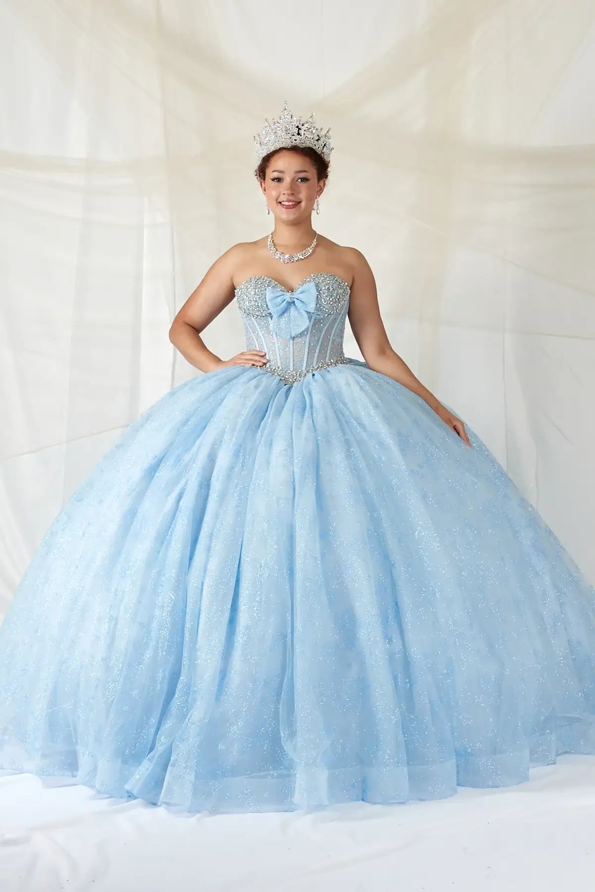 Bahama blue quinceañera ball gown with sheer corset bodice, crystal beading, glitter floral tulle and bow detail