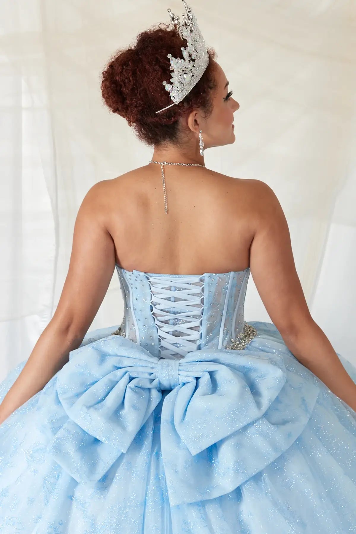 Bahama blue quinceañera ball gown with sheer corset bodice, crystal beading, glitter floral tulle and bow detail