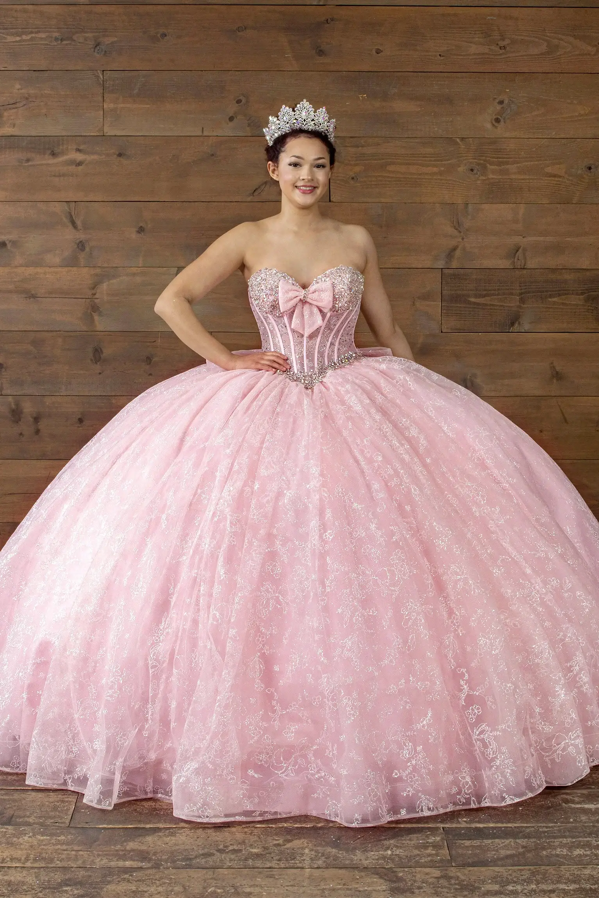 Pink quinceañera ball gown with crystal beaded bodice, glitter floral tulle and bow detail