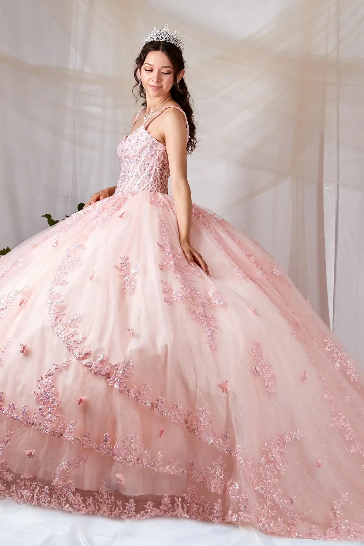 Blush quinceañera ball gown with sheer bodice, butterfly applique, spaghetti straps and lace skirt