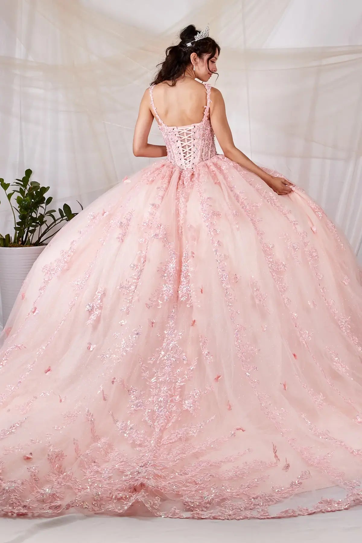 Blush quinceañera ball gown with 3D butterfly applique, sheer bodice, spaghetti straps and lace skirt