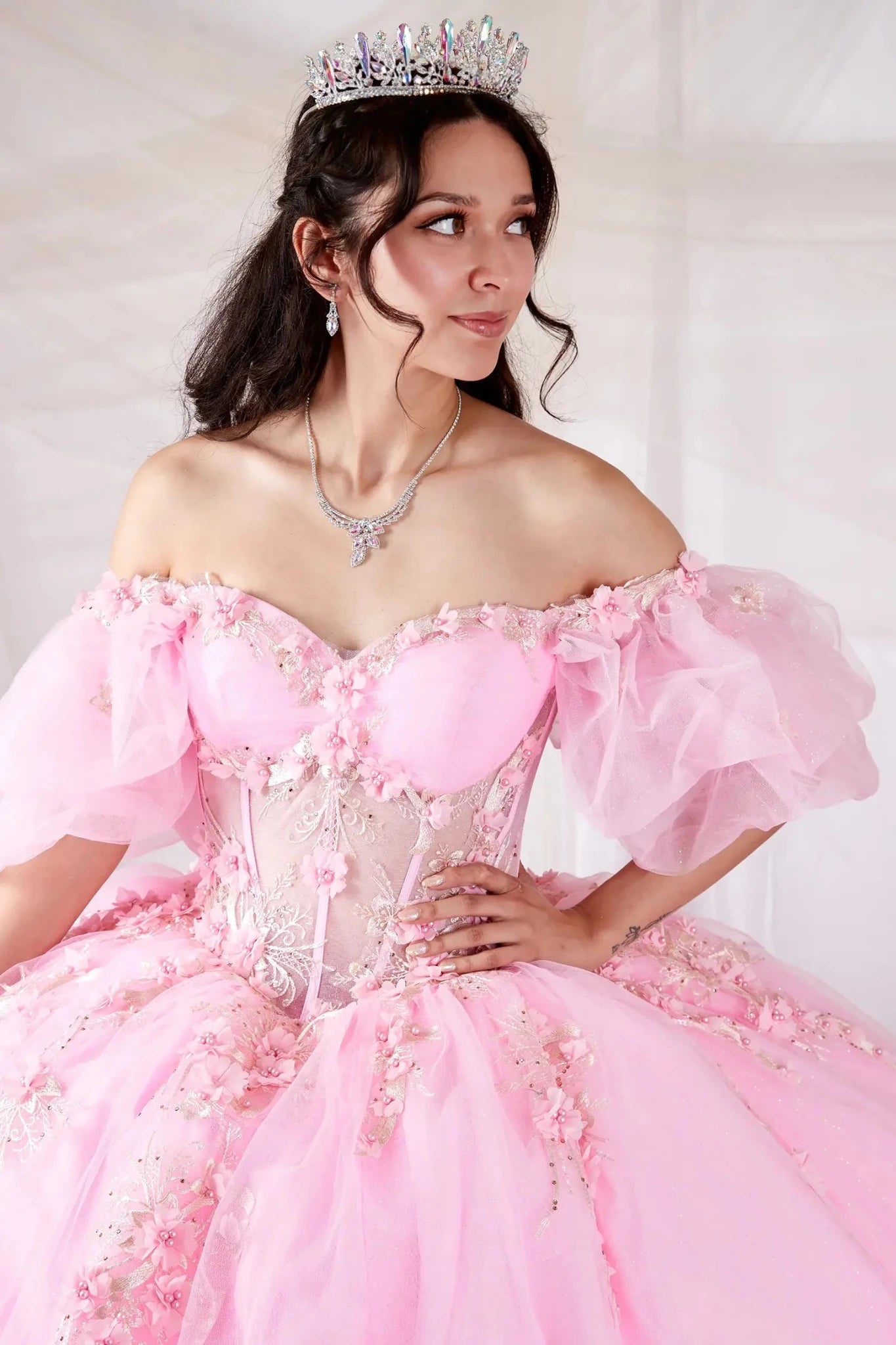 Blush quinceañera ball gown with off‑shoulder neckline, floral applique, sheer bodice and lace skirt
