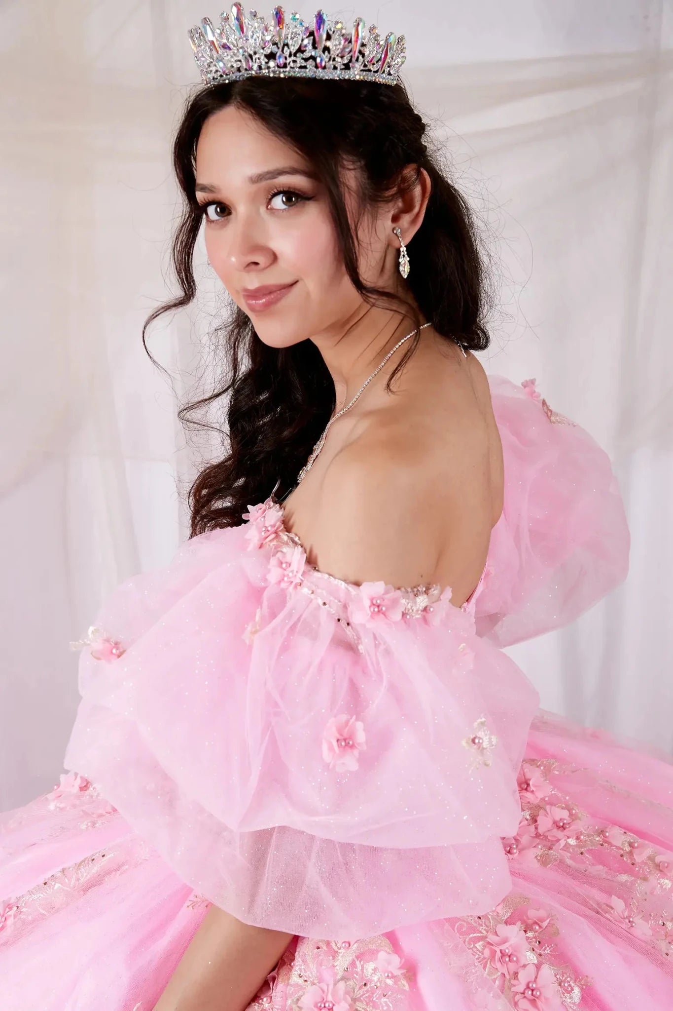 Blush quinceañera ball gown with 3D floral applique, sheer bodice, off‑shoulder neckline and puff sleeves