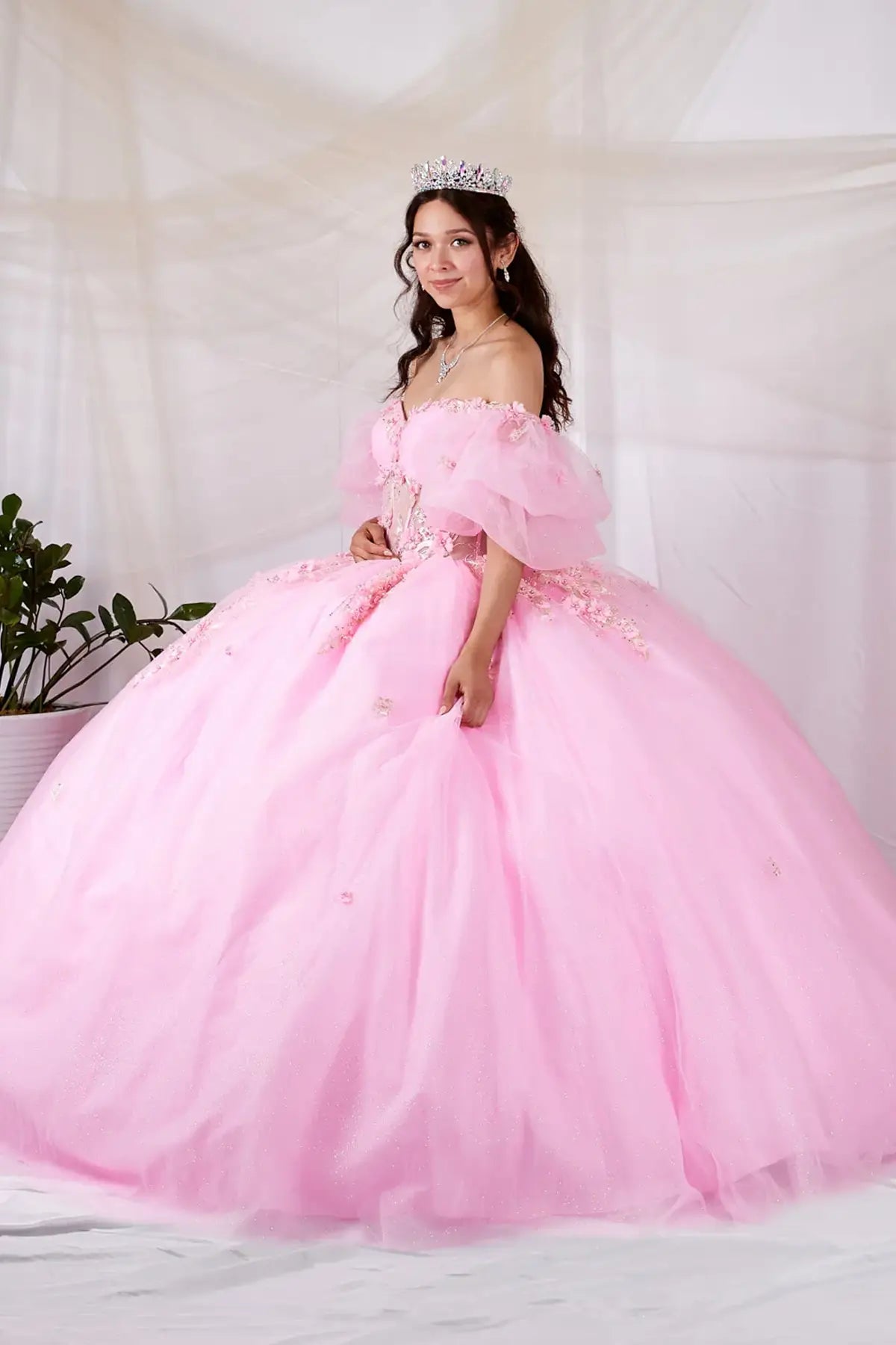 Blush quinceañera ball gown with sheer bodice, floral applique, off‑shoulder neckline and lace skirt