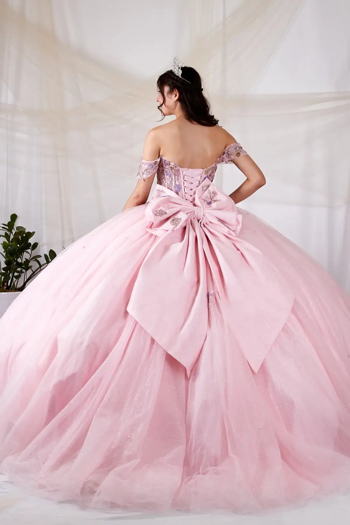 Blush quinceañera ball gown with multicolor floral sheer bodice, basque waist and detachable bow