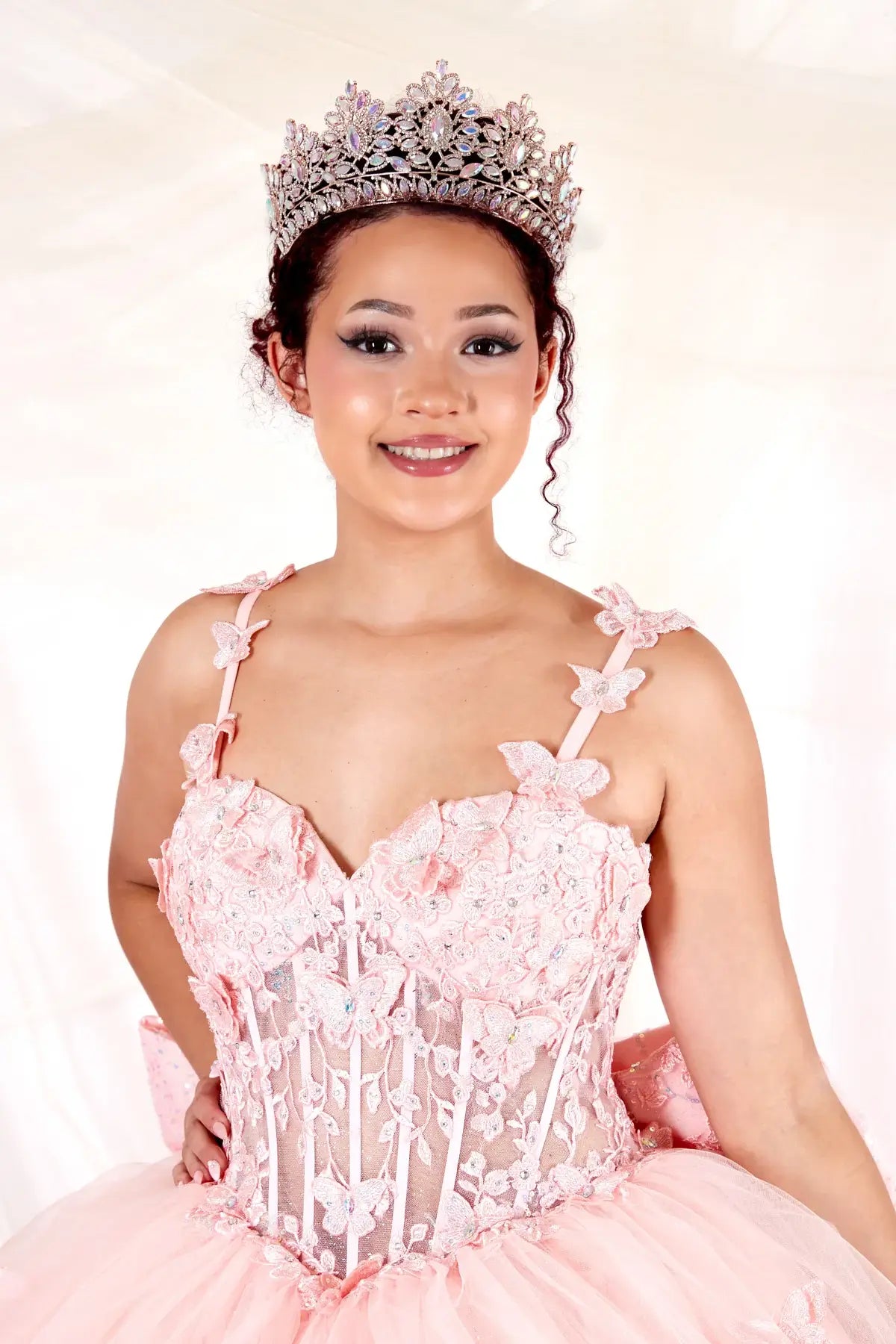 Blush quinceañera ball gown with 3D butterfly straps, layered tulle skirt and detachable bow