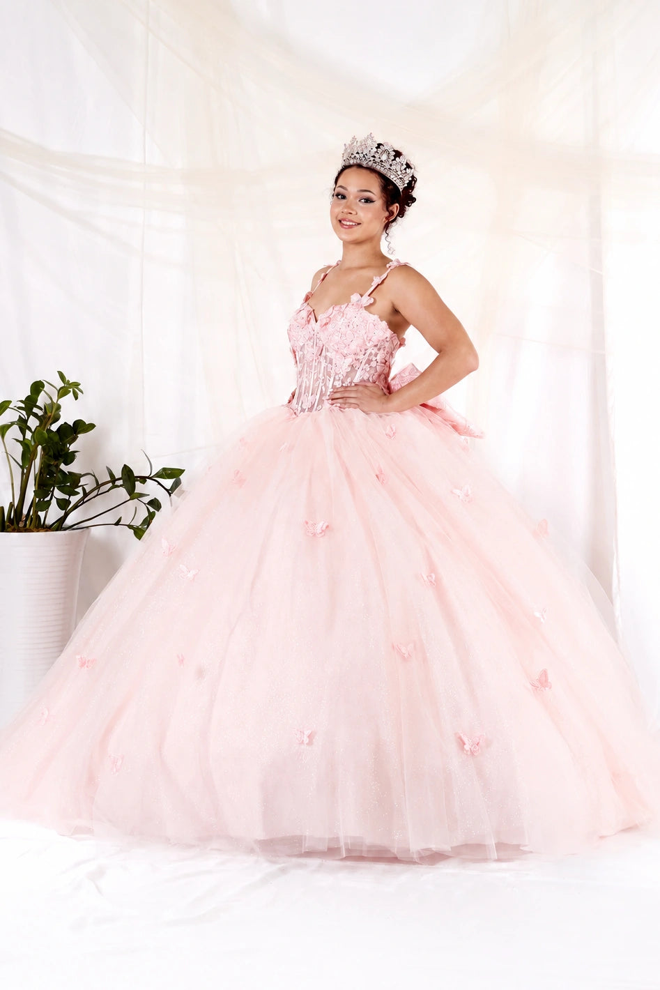 Blush quinceañera ball gown with butterfly straps, layered tulle skirt and detachable bow