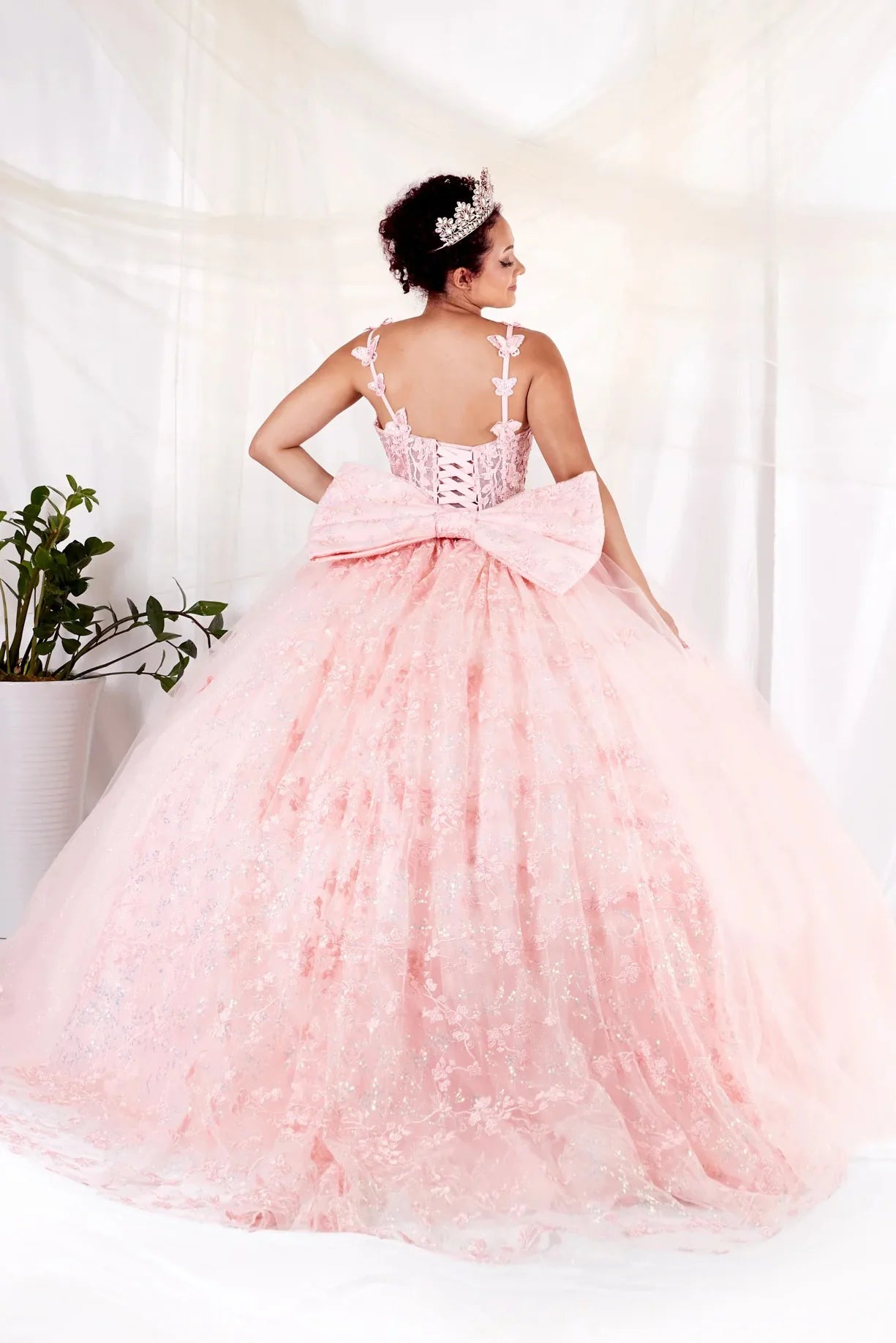 Blush quinceañera ball gown with 3D butterfly straps, layered tulle skirt and detachable bow