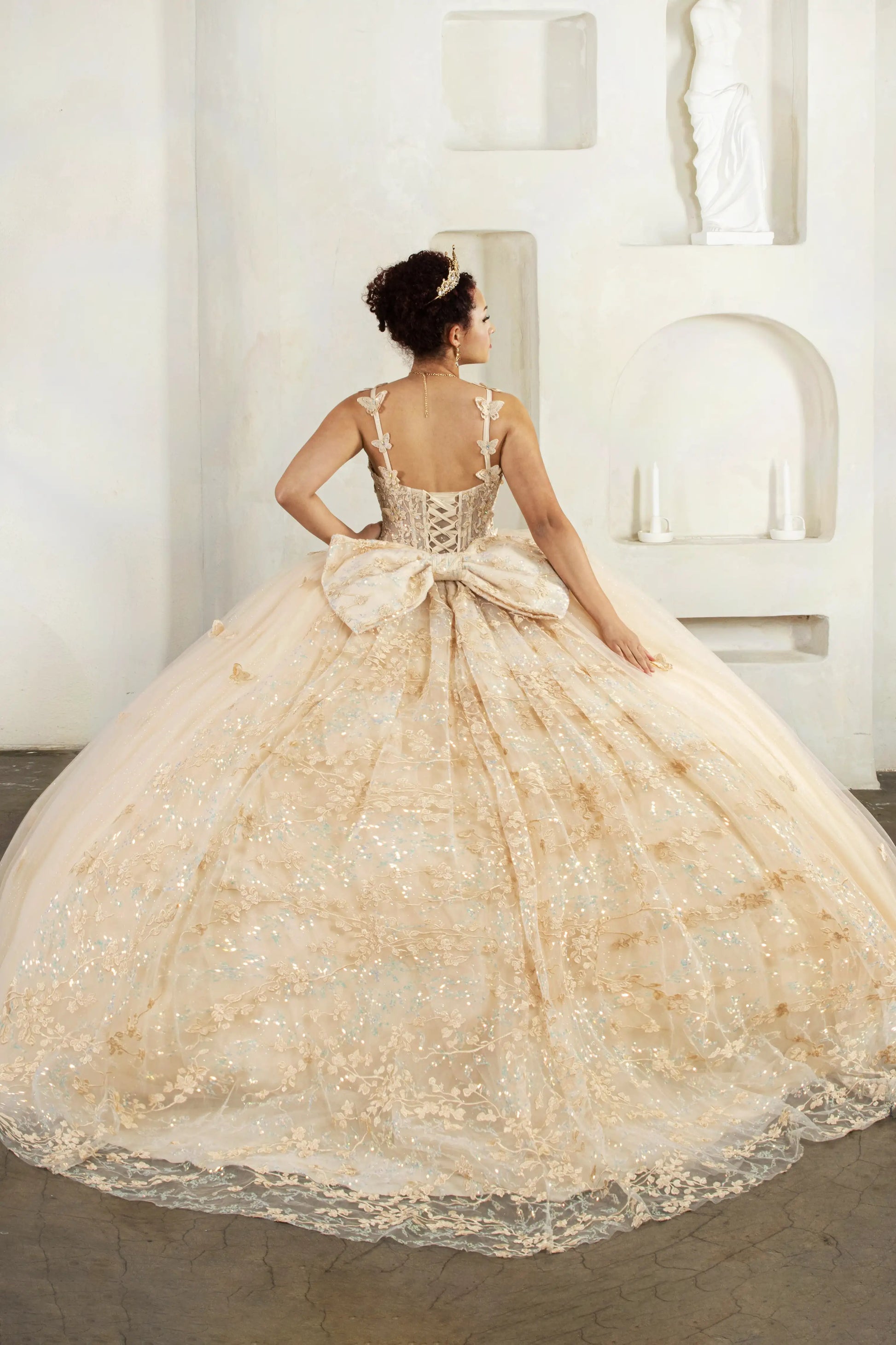 Champagne quinceañera ball gown with 3D butterfly straps, layered tulle skirt and detachable bow