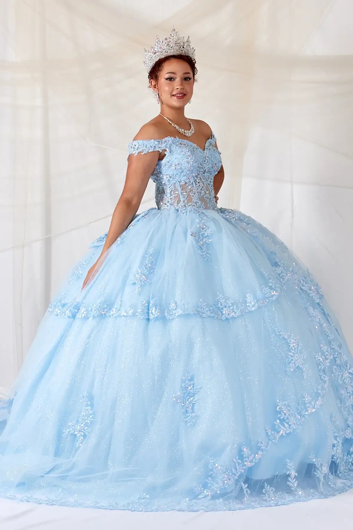 Bahama blue quinceañera ball gown with sheer sweetheart bodice, floral embroidery and glitter tulle skirt