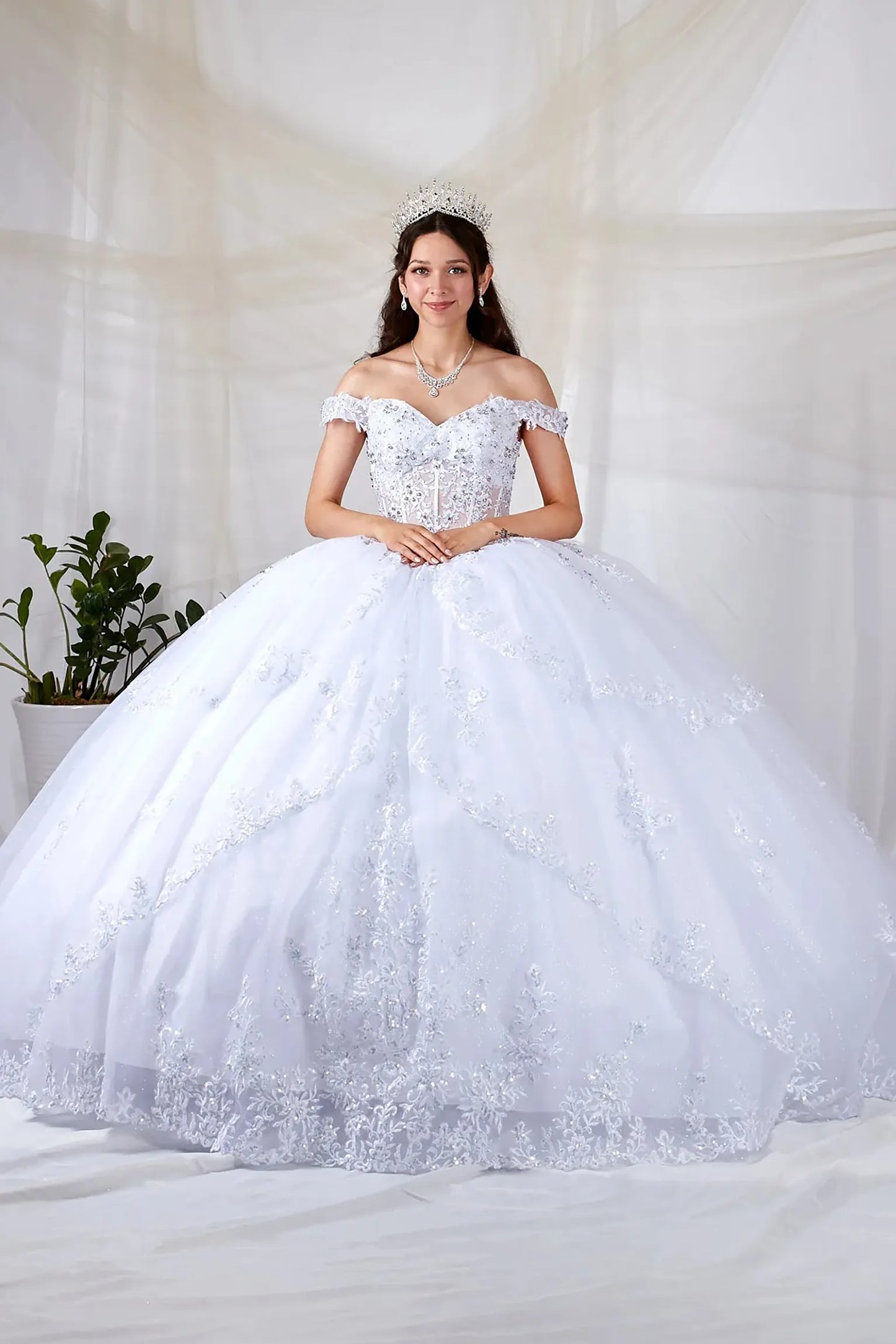 White quinceañera ball gown with sheer sweetheart bodice, floral embroidery and glitter tulle skirt