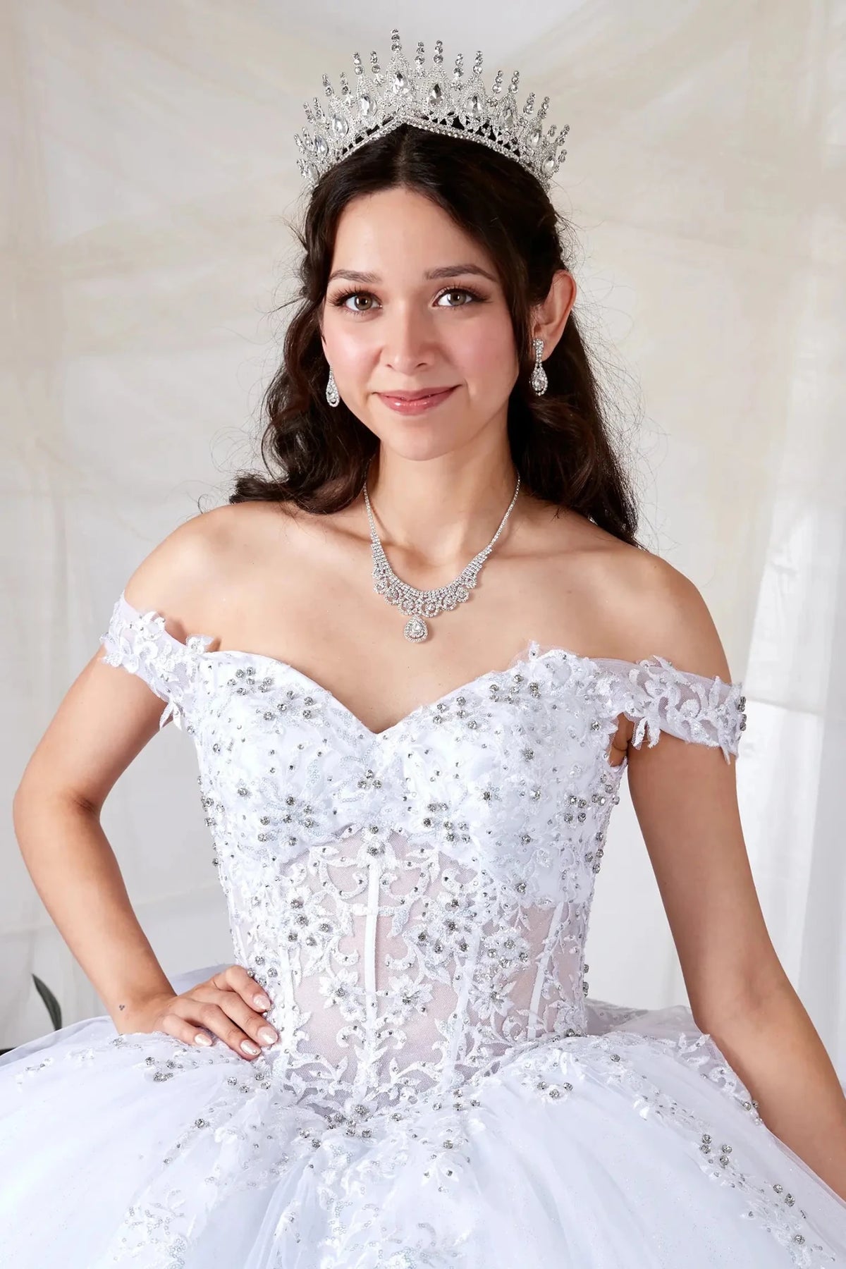 White quinceañera ball gown with sheer sweetheart bodice, floral embroidery, glitter tulle and silver beadwork