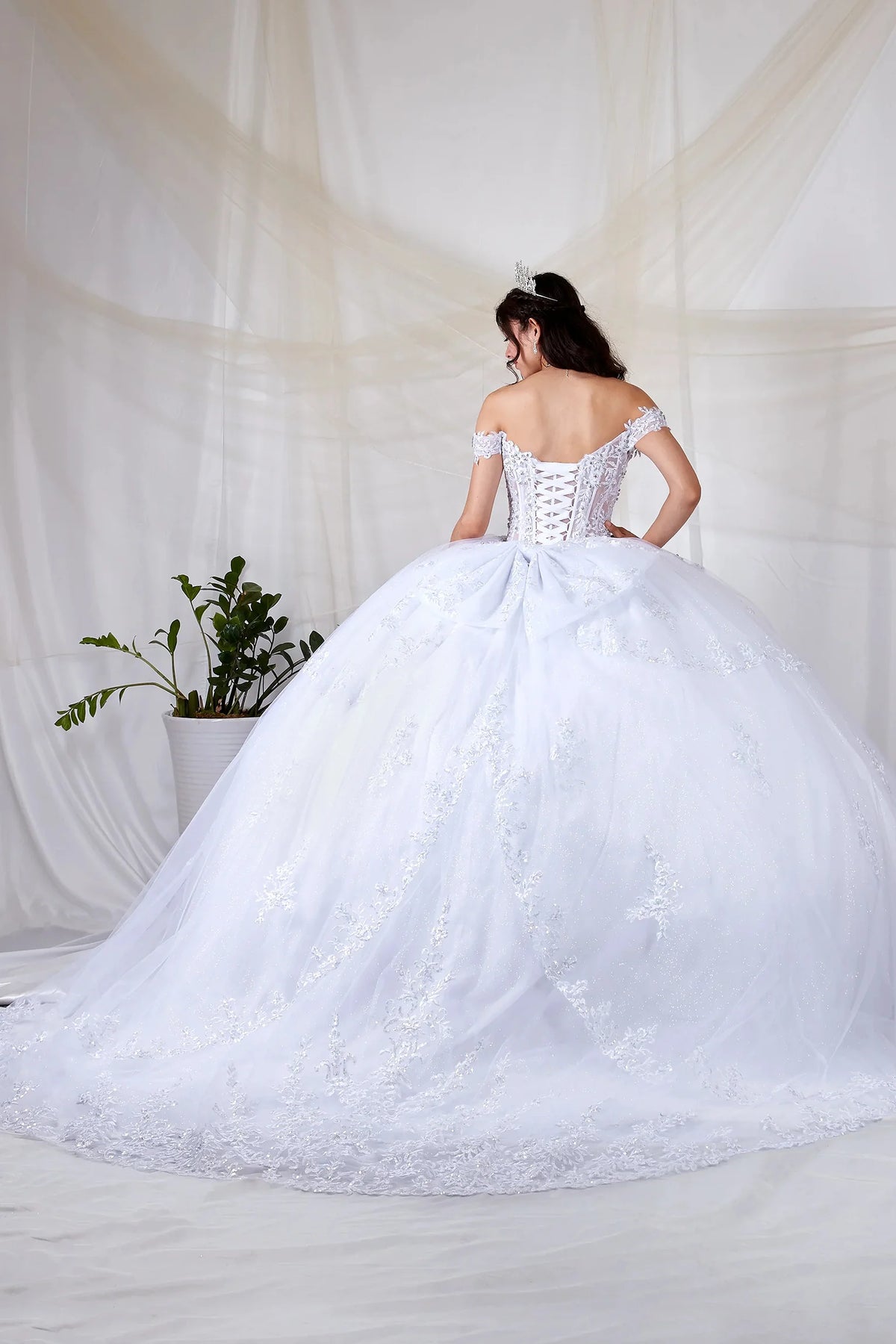 White quinceañera ball gown with sheer sweetheart bodice, floral embroidery and glitter tulle skirt