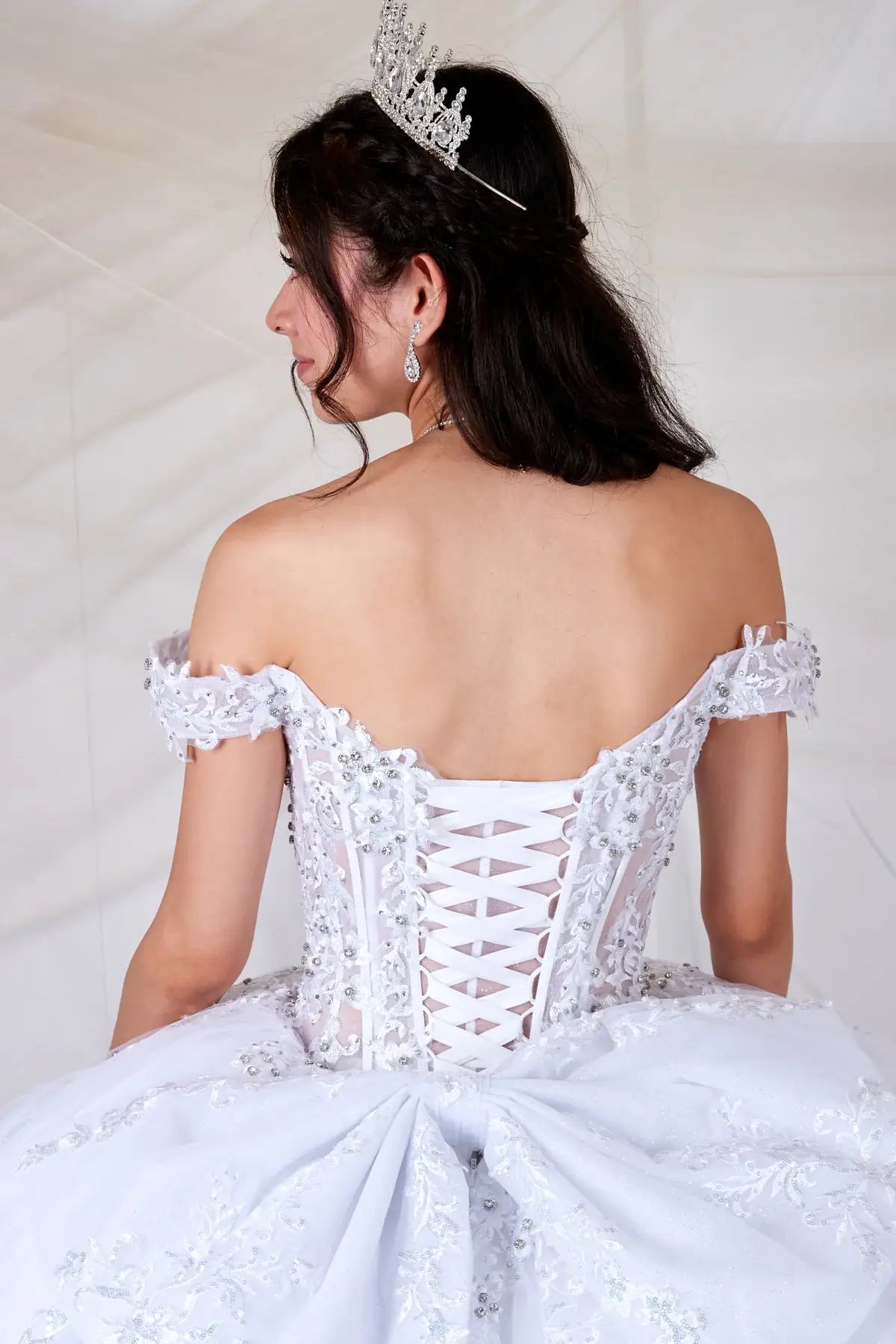 White quinceañera ball gown with sheer sweetheart bodice, floral embroidery and glitter tulle skirt