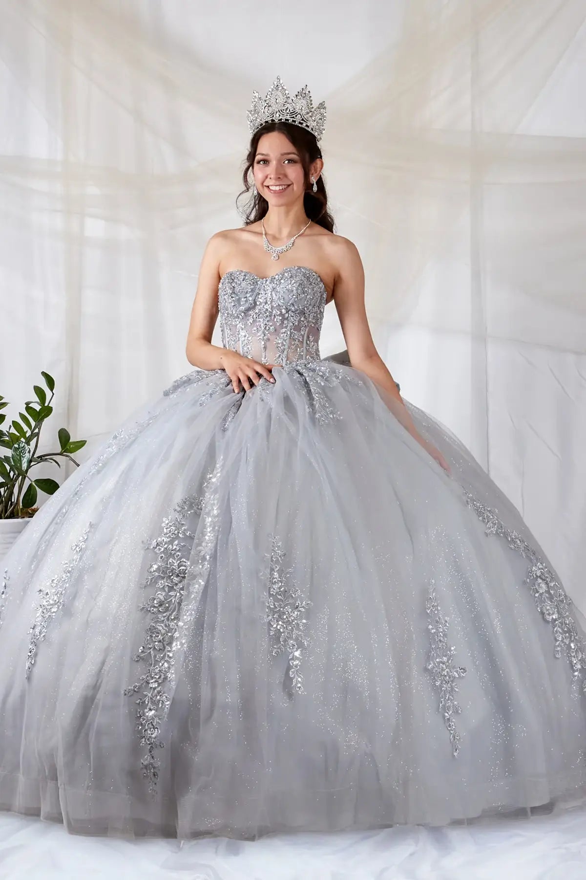 Silver quinceañera ball gown with sheer sweetheart bodice, floral embroidery and glitter tulle skirt
