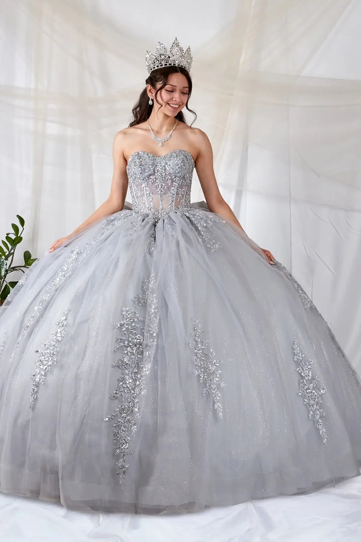 Silver quinceañera ball gown with sheer sweetheart bodice, floral embroidery and glitter tulle skirt
