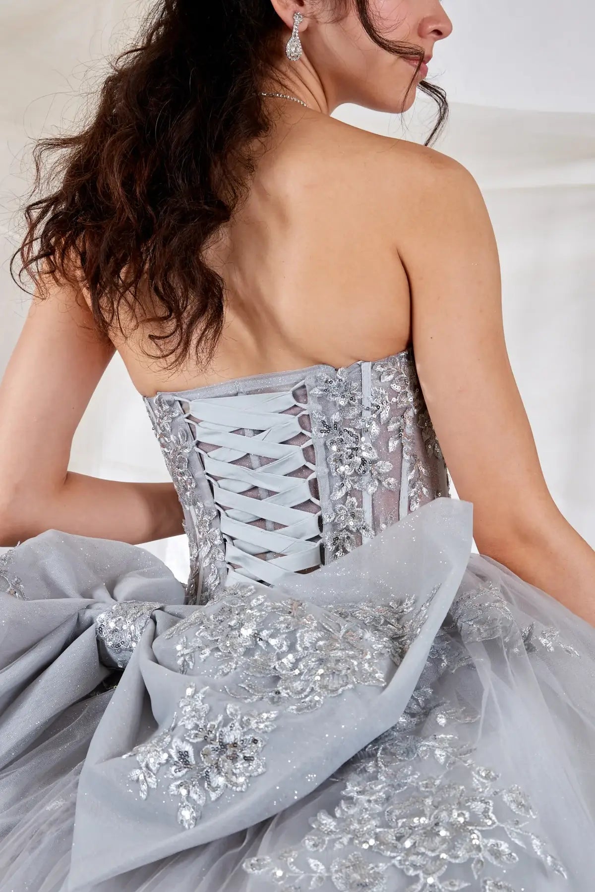 Silver quinceañera ball gown with sheer sweetheart bodice, floral embroidery and glitter tulle skirt