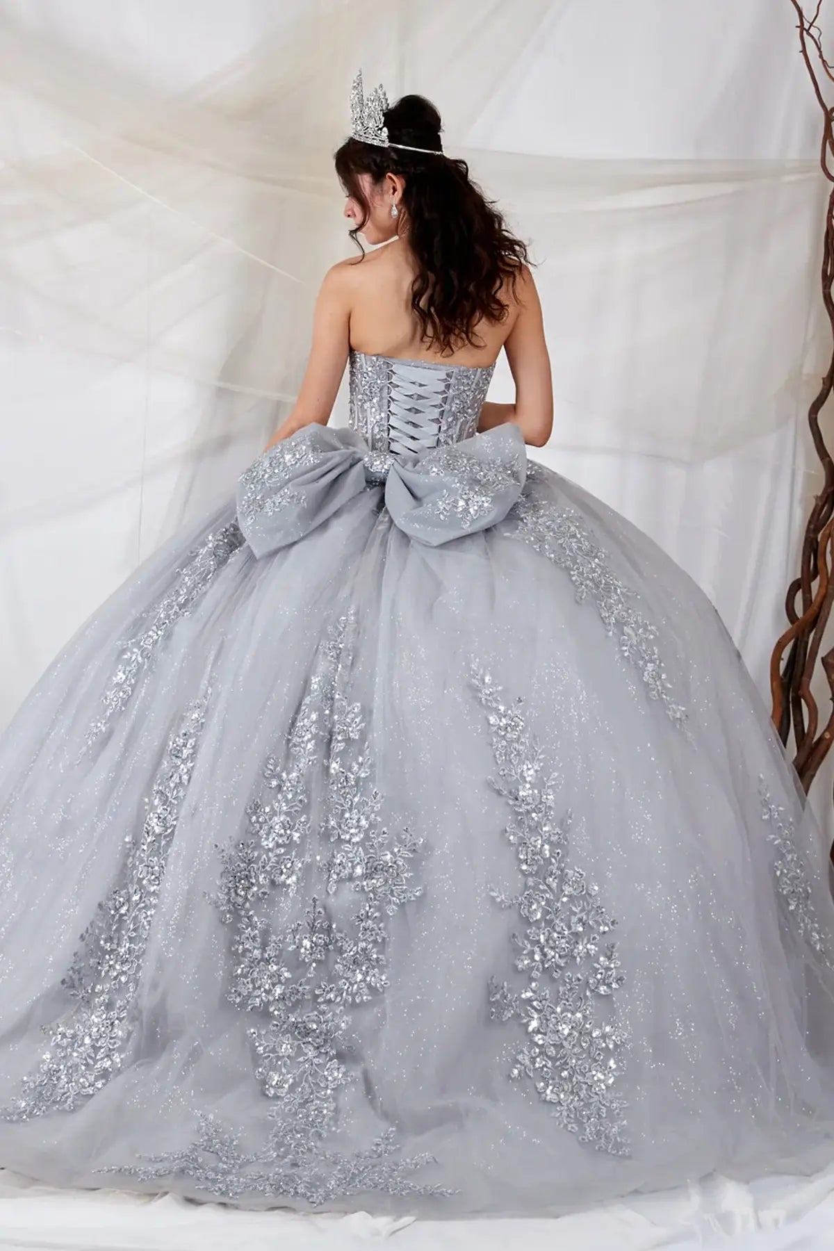 Silver quinceañera ball gown with sheer sweetheart bodice, floral embroidery and glitter tulle skirt