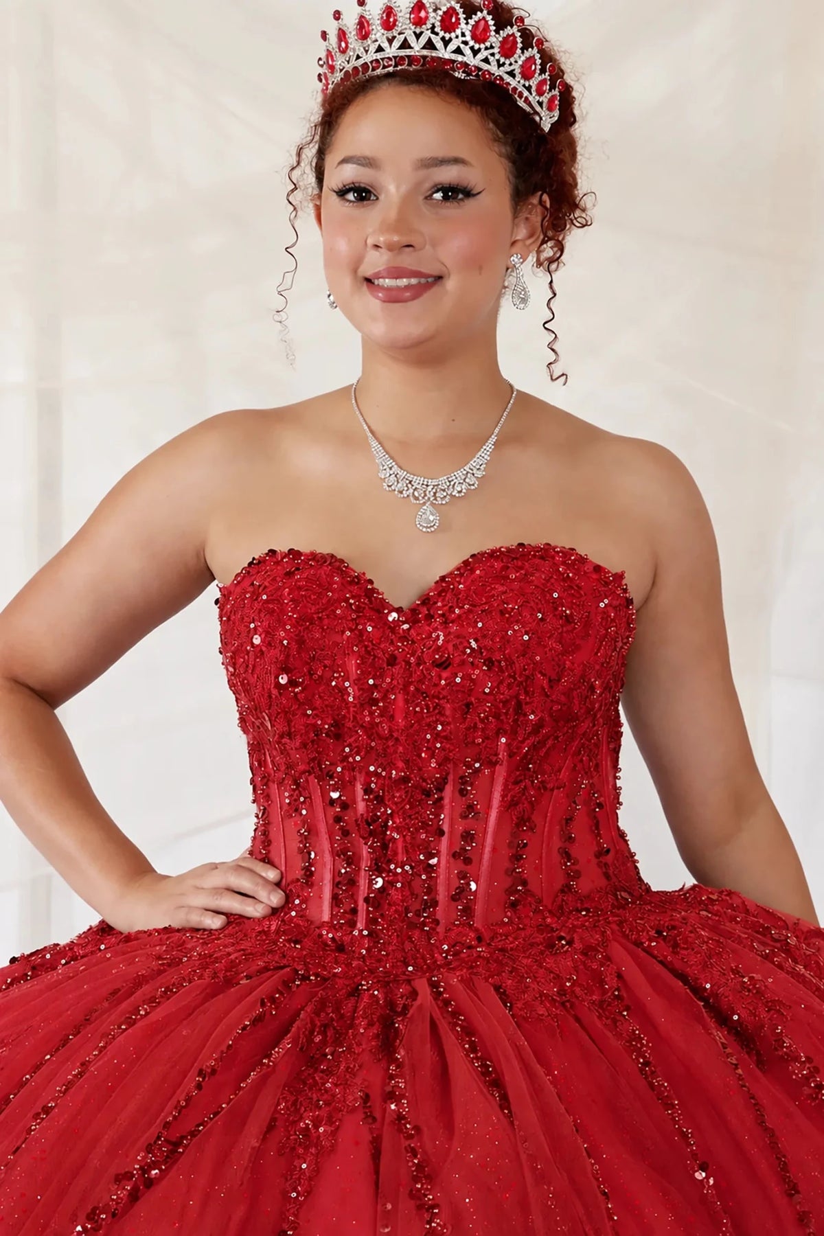 a red quinceañera ball gown with a sweetheart neckline, strapless design, and sparkling sequined bodice