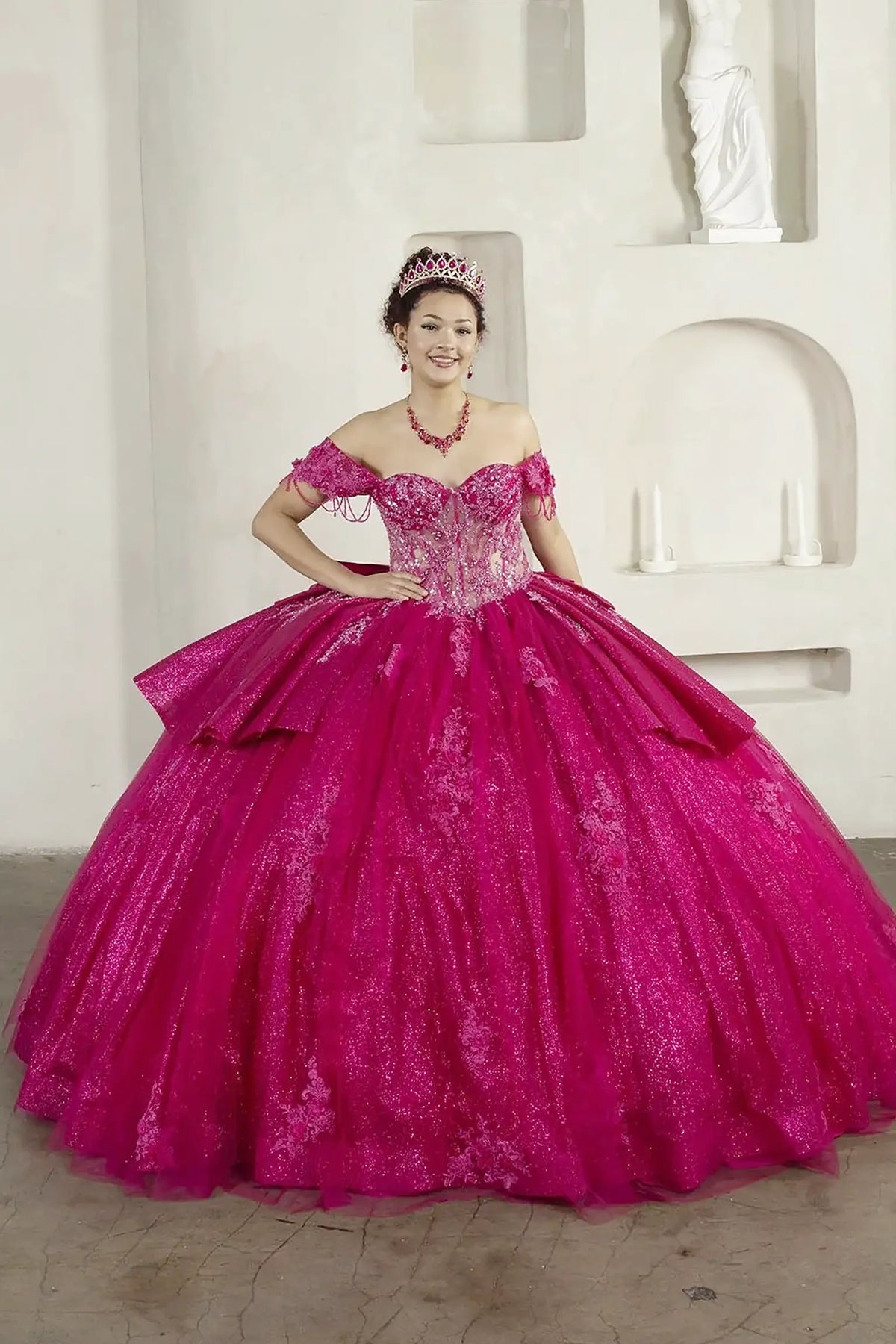 Fuchsia quinceañera ball gown with beaded fringe straps, embroidered lace and ruffled train