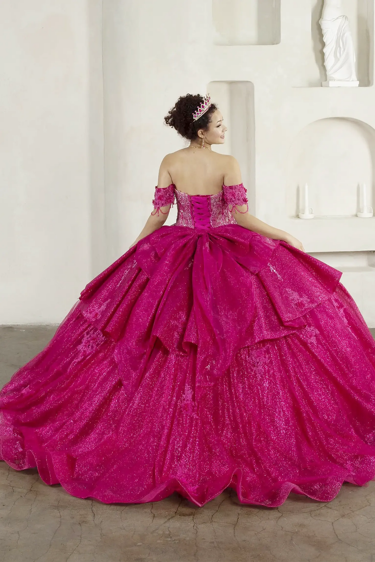Fuchsia quinceañera ball gown with beaded fringe straps, embroidered lace and ruffled train