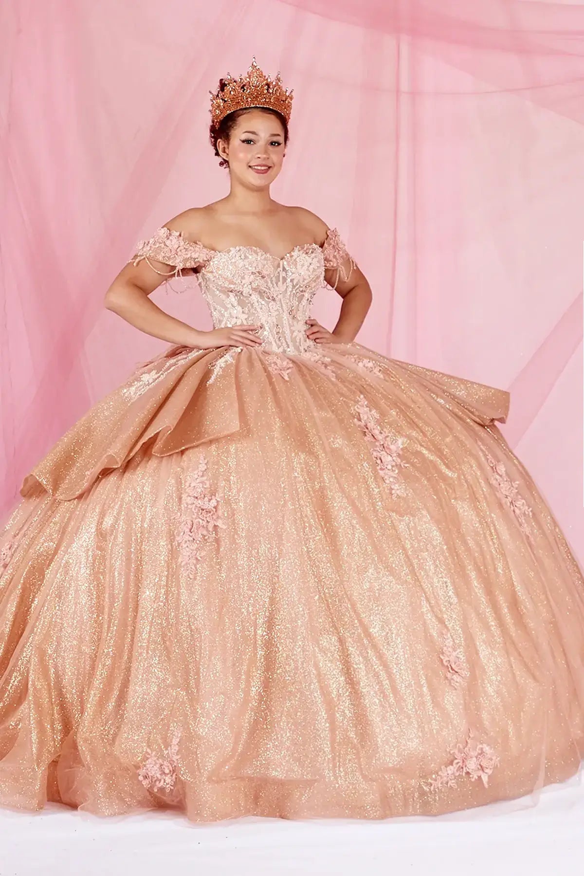 Rose gold quinceañera ball gown with beaded fringe straps, gold embroidered lace and ruffled train