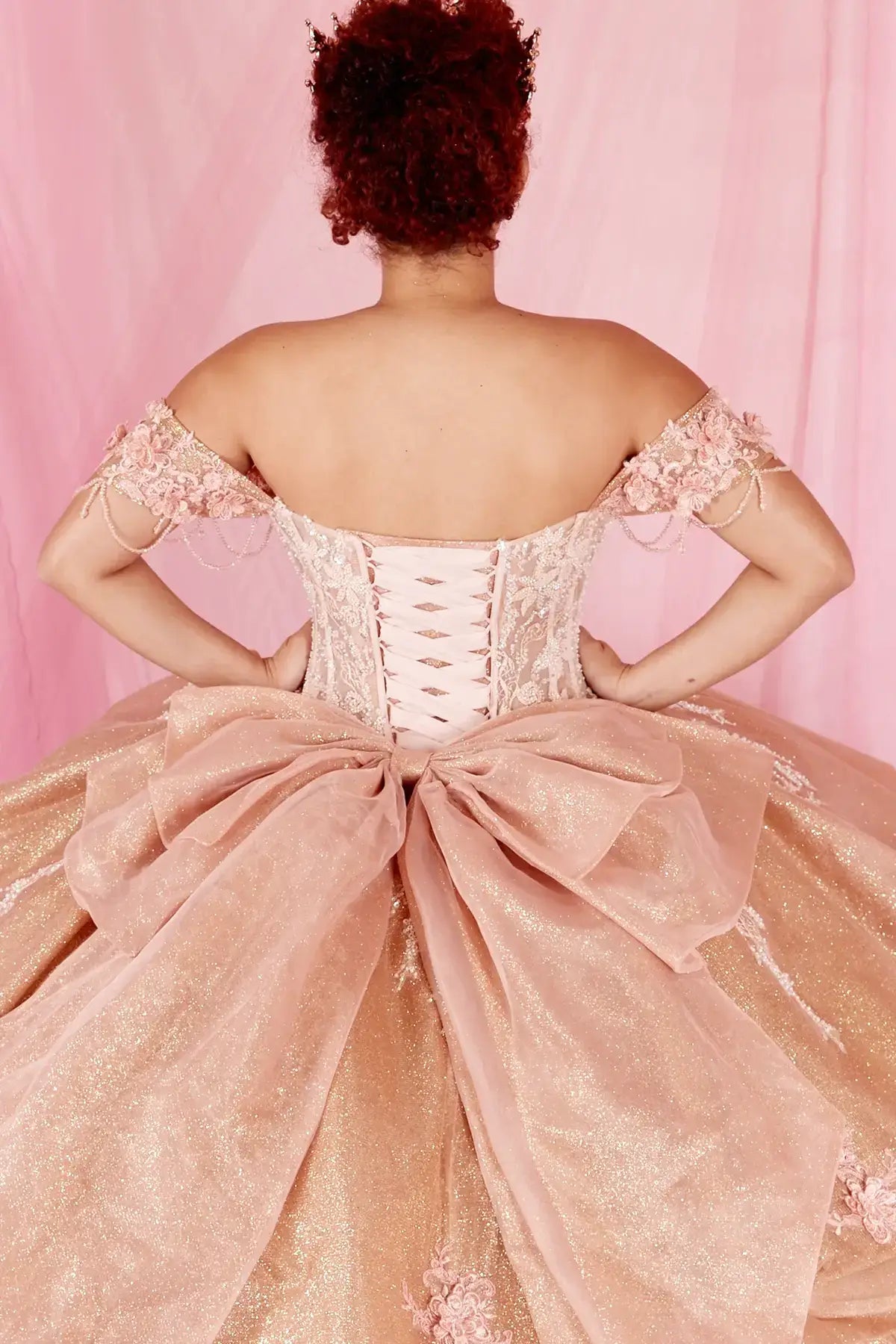 Rose gold quinceañera ball gown with beaded fringe straps, gold embroidered lace and ruffled train