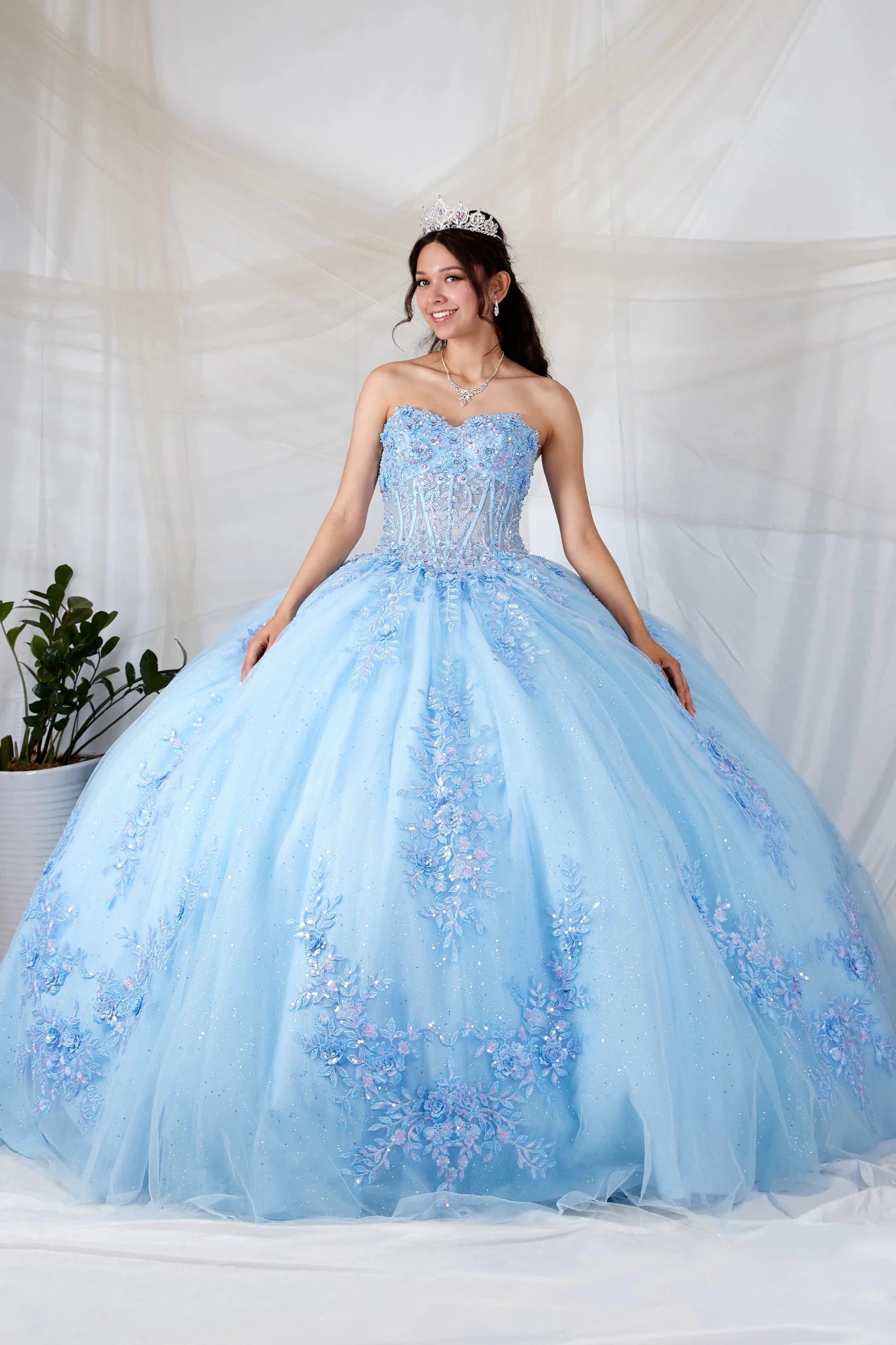 Light blue quinceañera ball gown with strapless bodice, beaded embroidery, floral applique and glitter tulle skirt