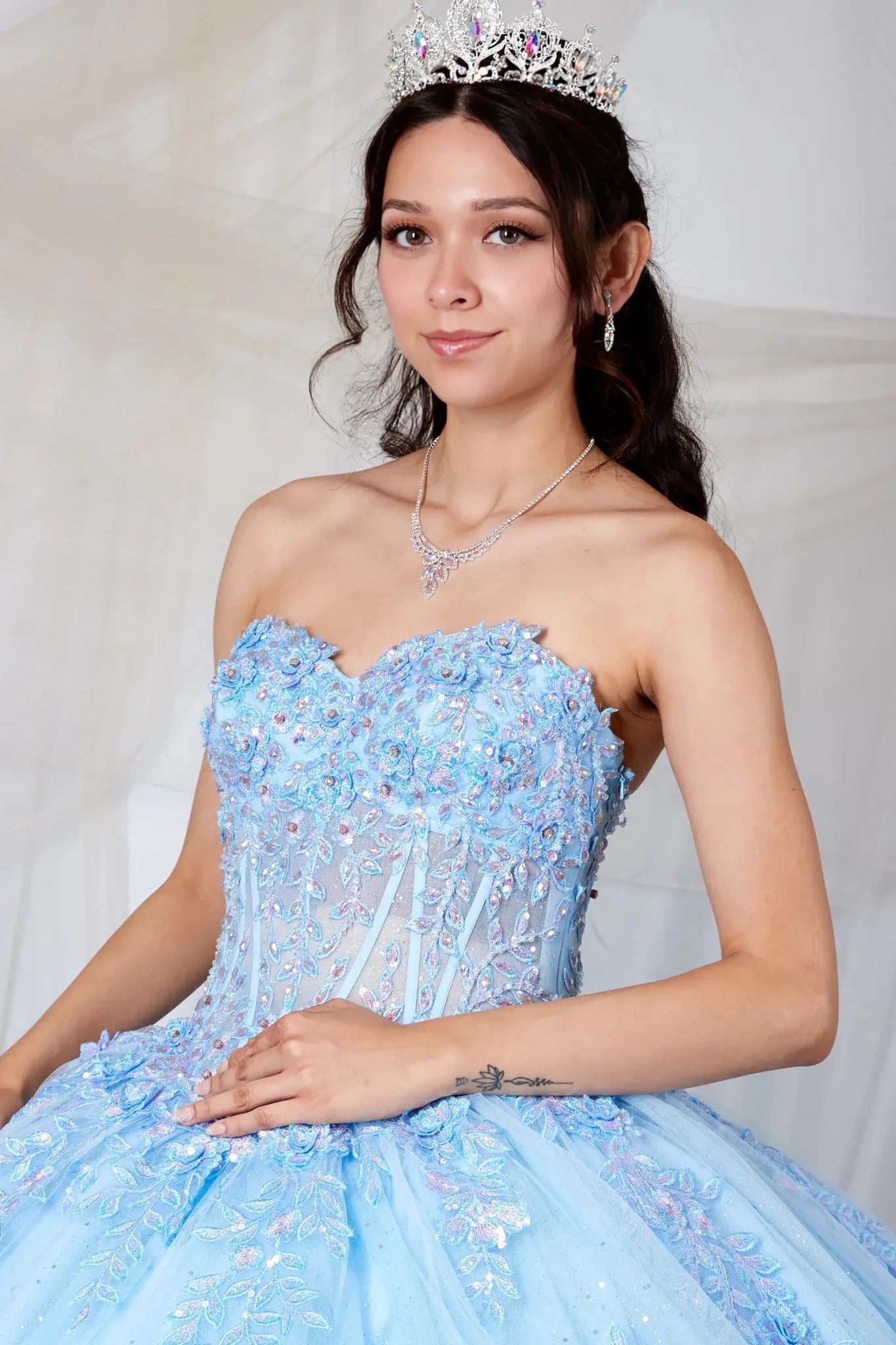Light blue quinceañera ball gown with strapless bodice, beaded embroidery, floral applique and glitter tulle skirt