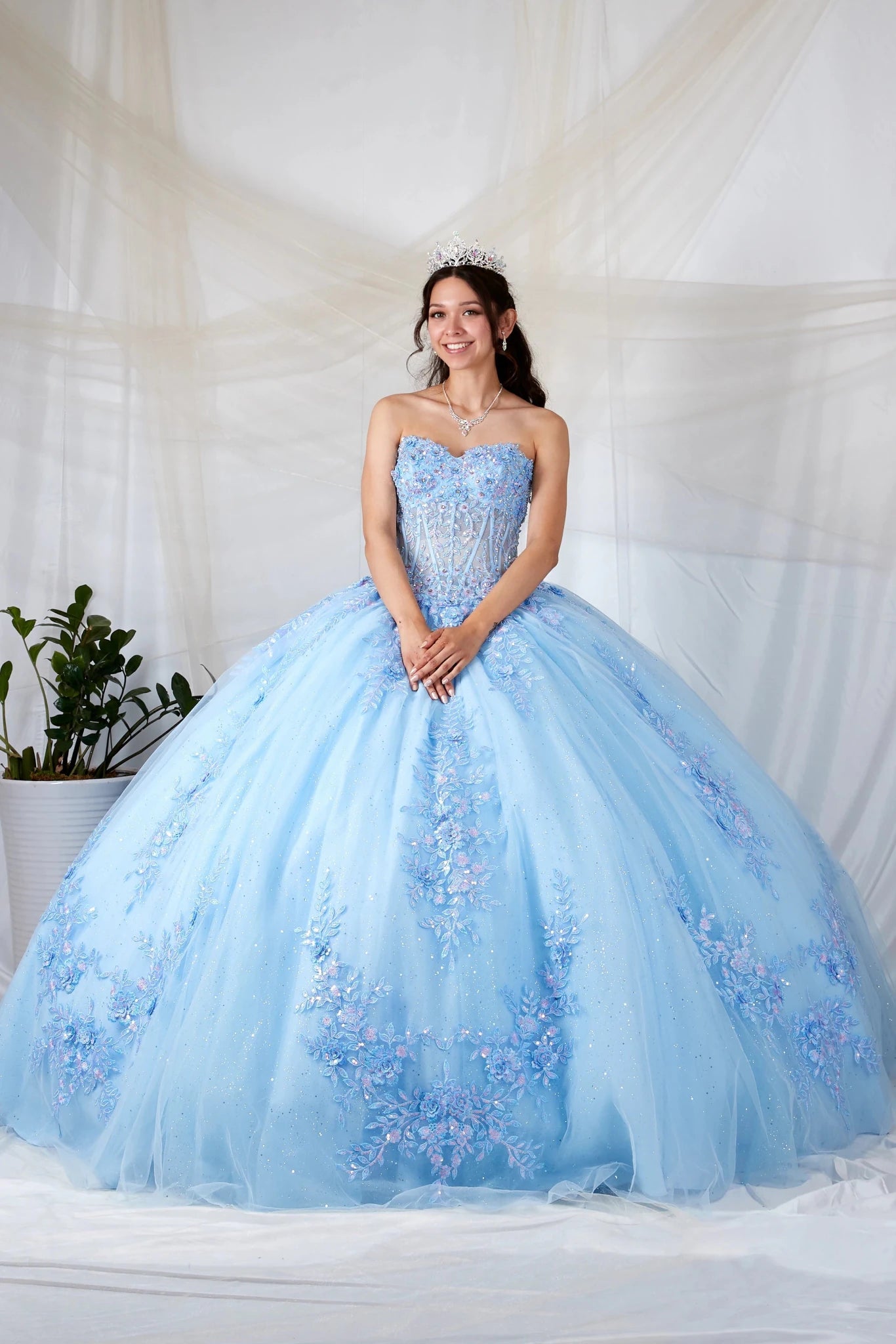 Light blue quinceañera ball gown with beaded bodice, floral applique and glitter tulle skirt