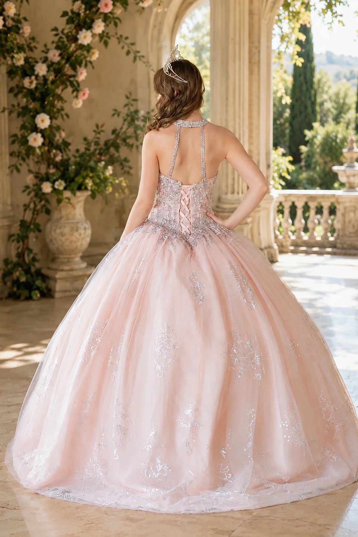 From behind, the Blush Pink quinceañera ball gown reveals a shaped lace-up back and the sweep of the full skirt.
