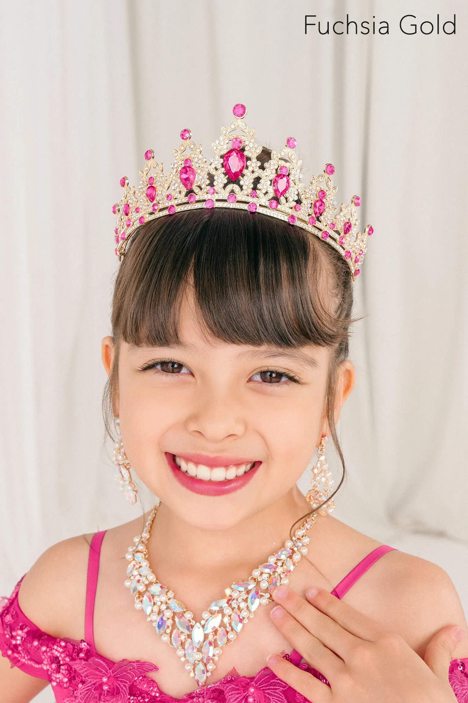 Young girl wearing a fuchsia gold tiara and necklace