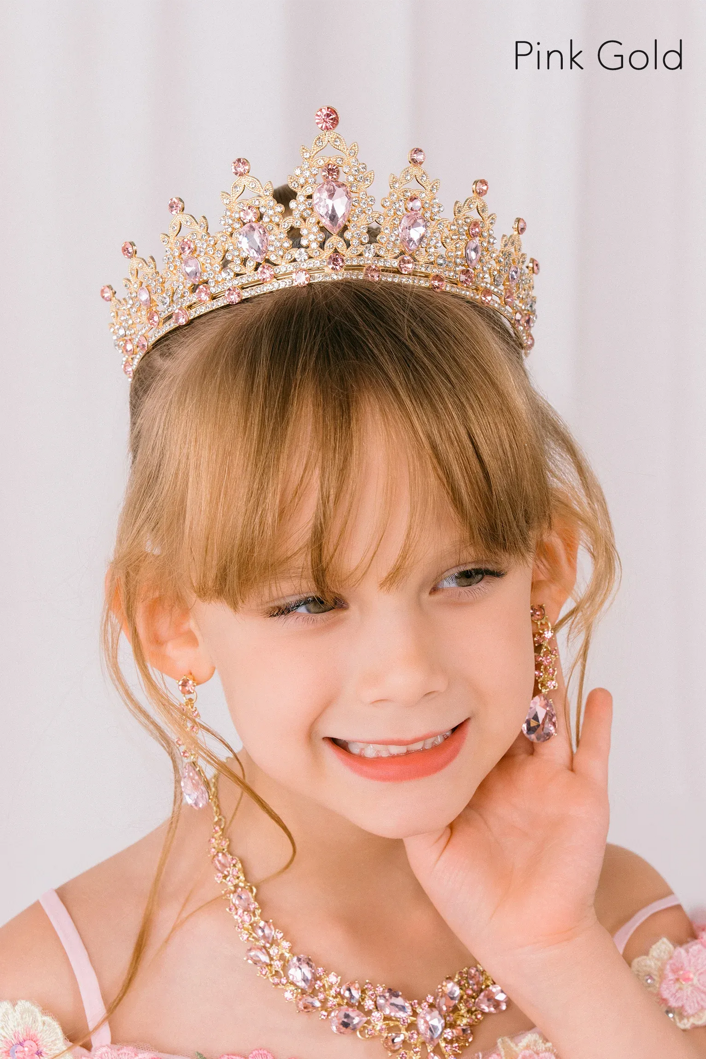 Young girl wearing a pink rhinestone gold tiara 