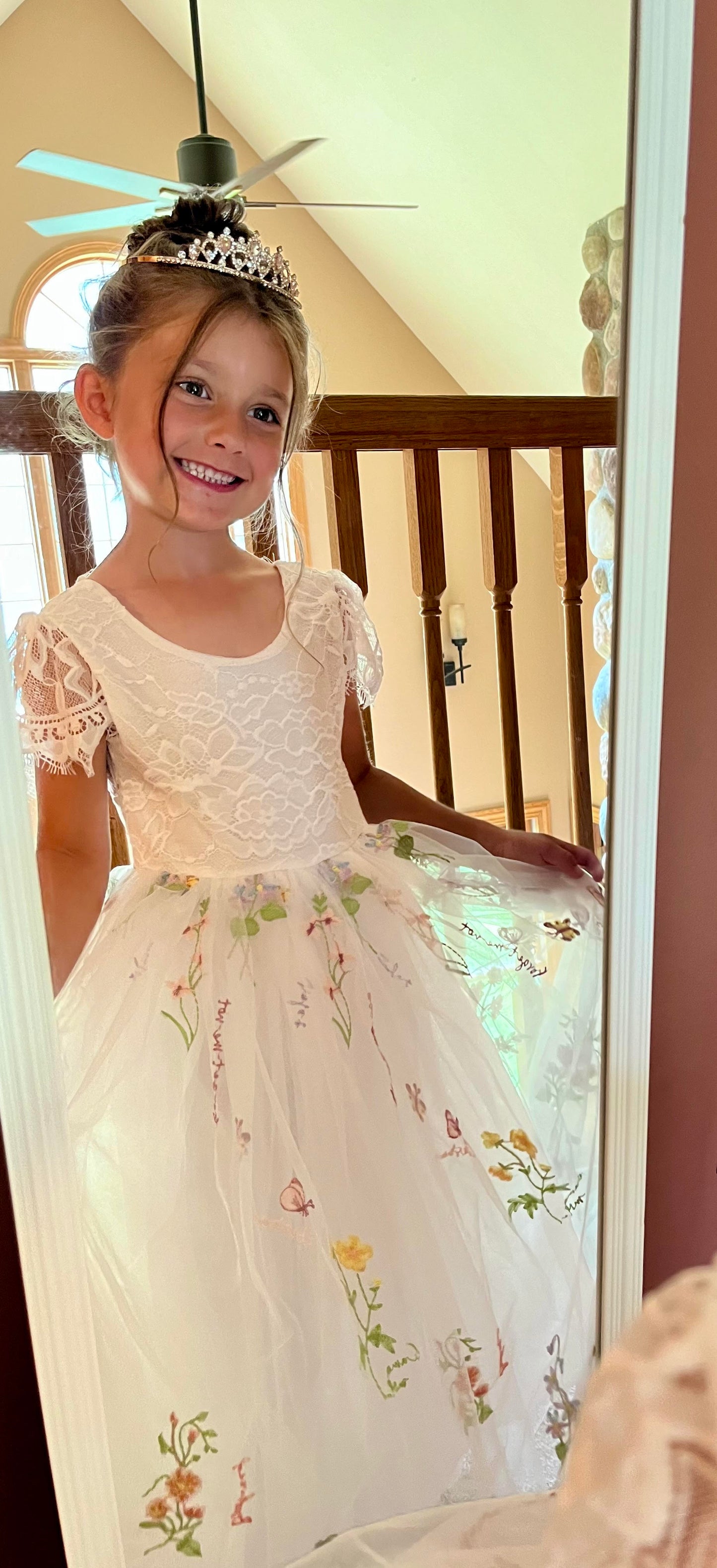 V-Back Soft Lace Top Embroidered Floral Tulle Cap Sleeves Dress | Flower Girl Dress | Special Occasion Dress – Hazel Dress front view through the mirror with a tiara