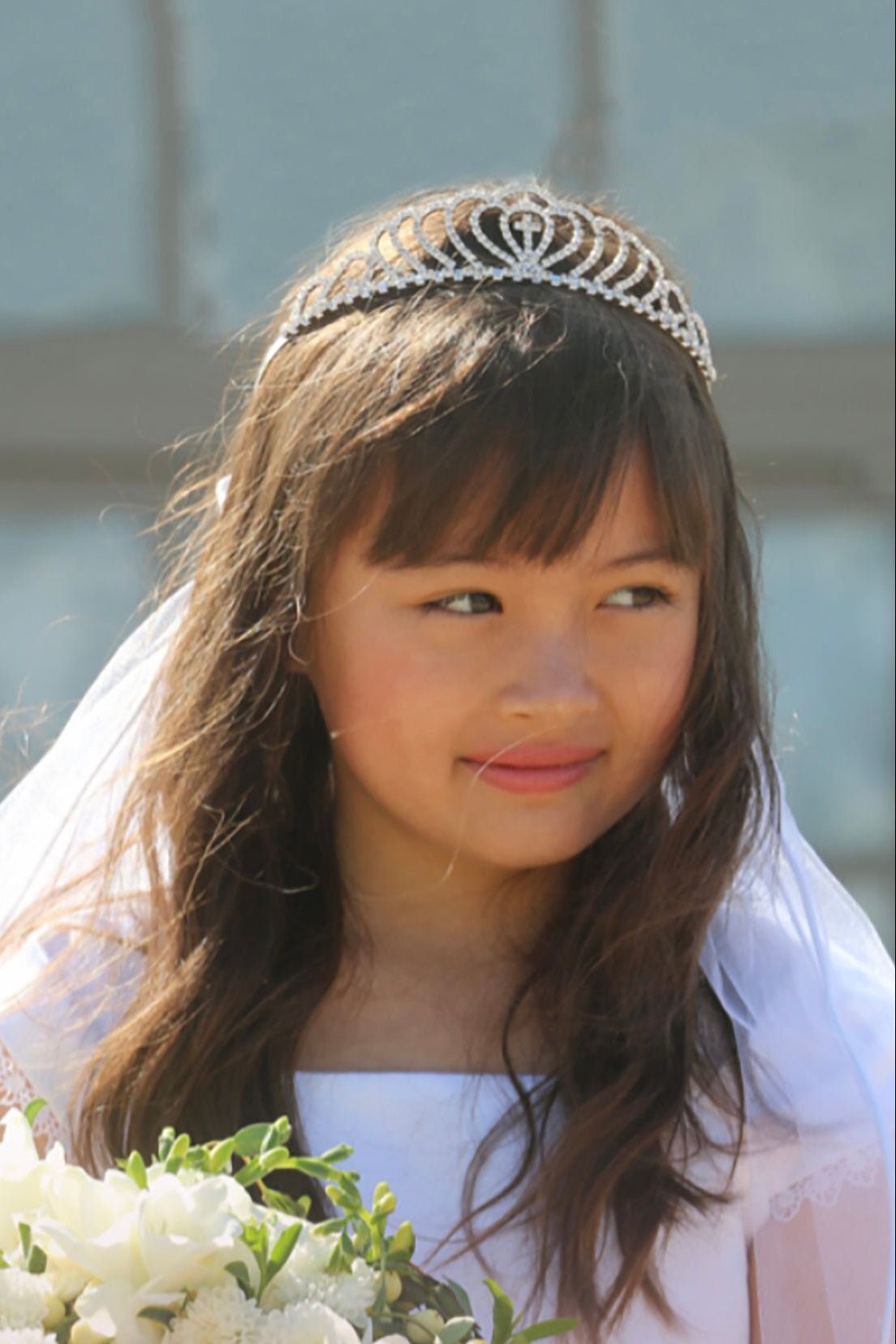 White rhinestone floral cross first communion tiara and two-tier veil.