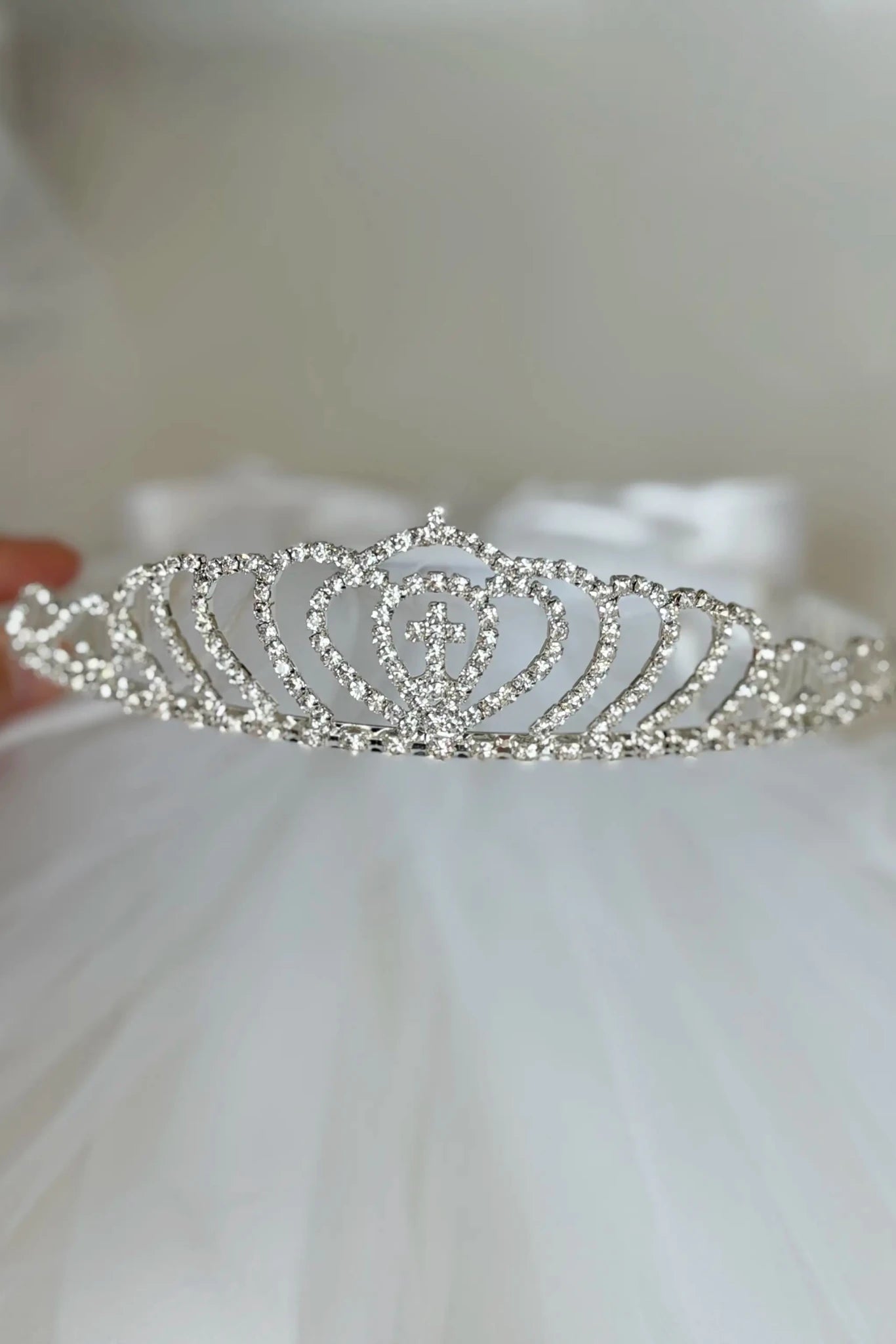 White rhinestone cross first communion tiara and two-tier veil.