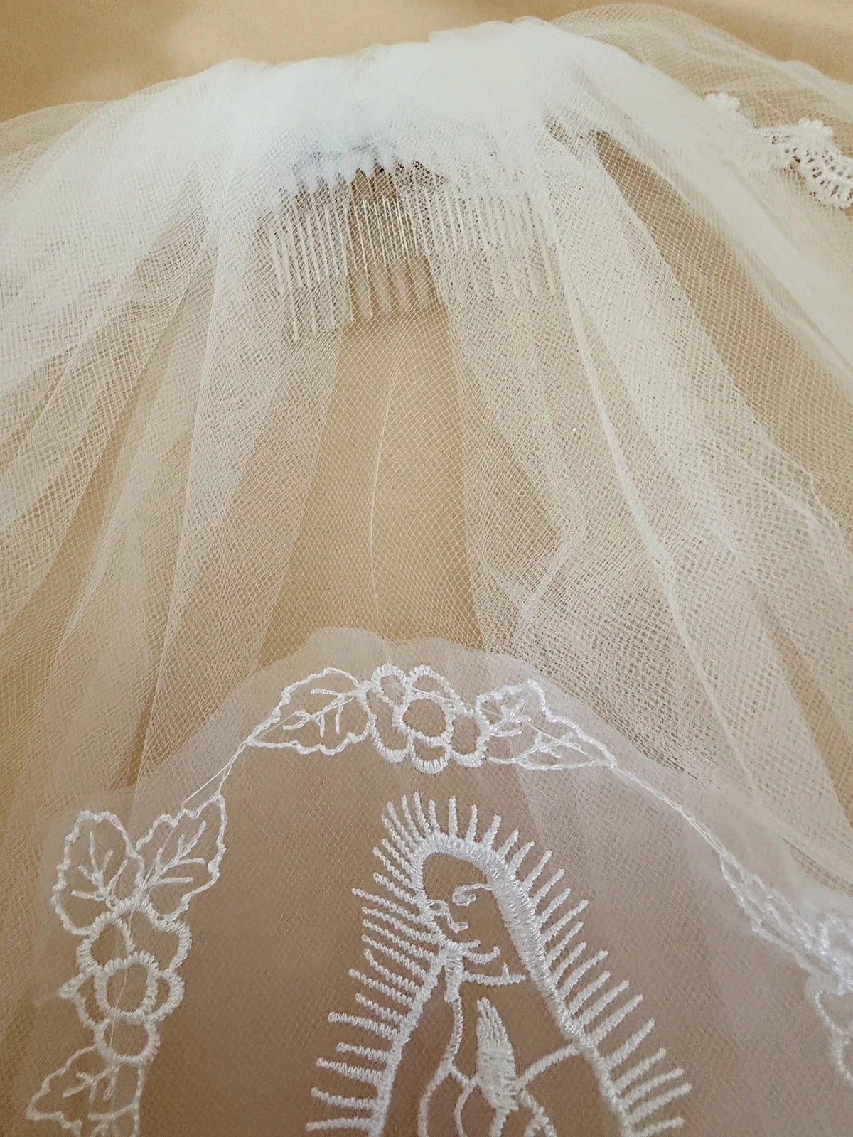 White pearl rhinestone lace Virgin Mary embroidered first communion veil, close-up, embellishment detail.