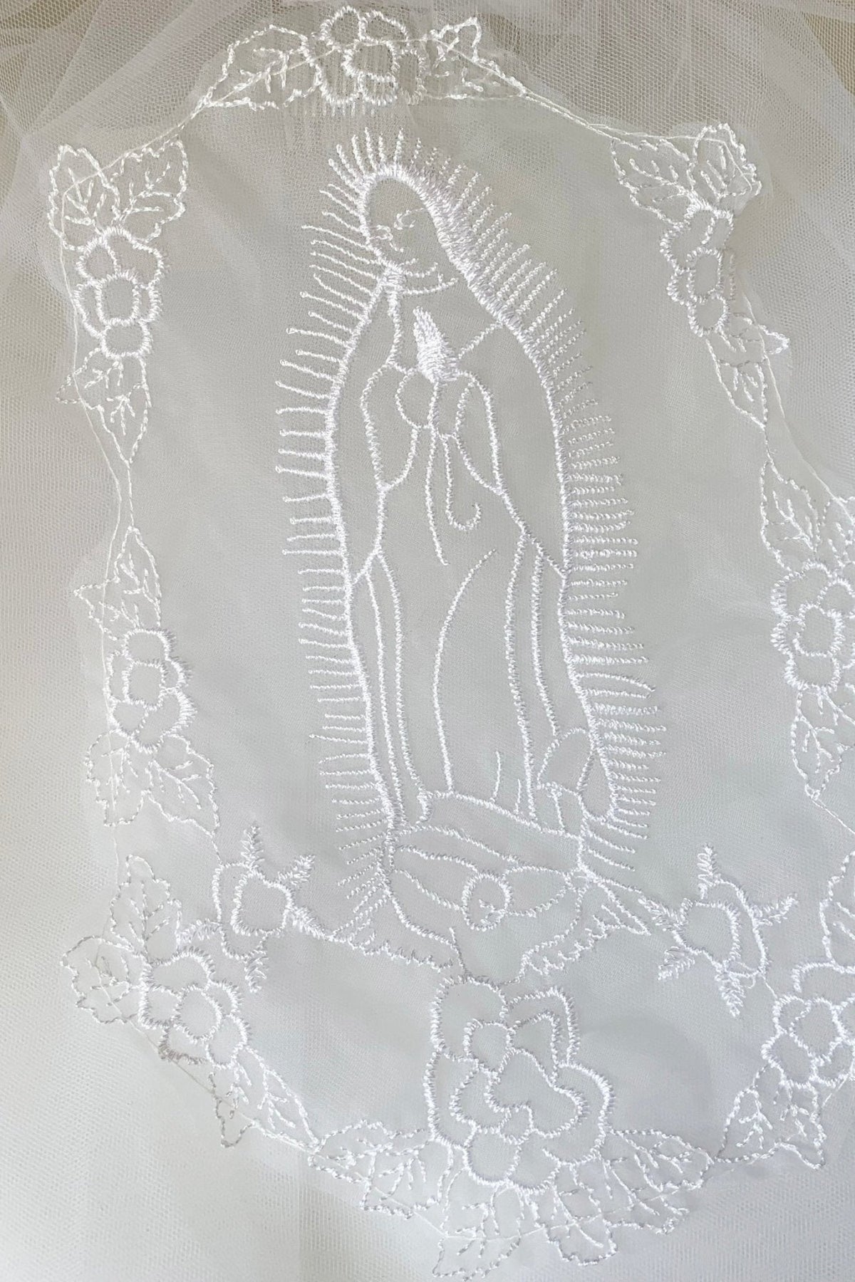 White pearl rhinestone lace Virgin Mary embroidered first communion veil, close-up.