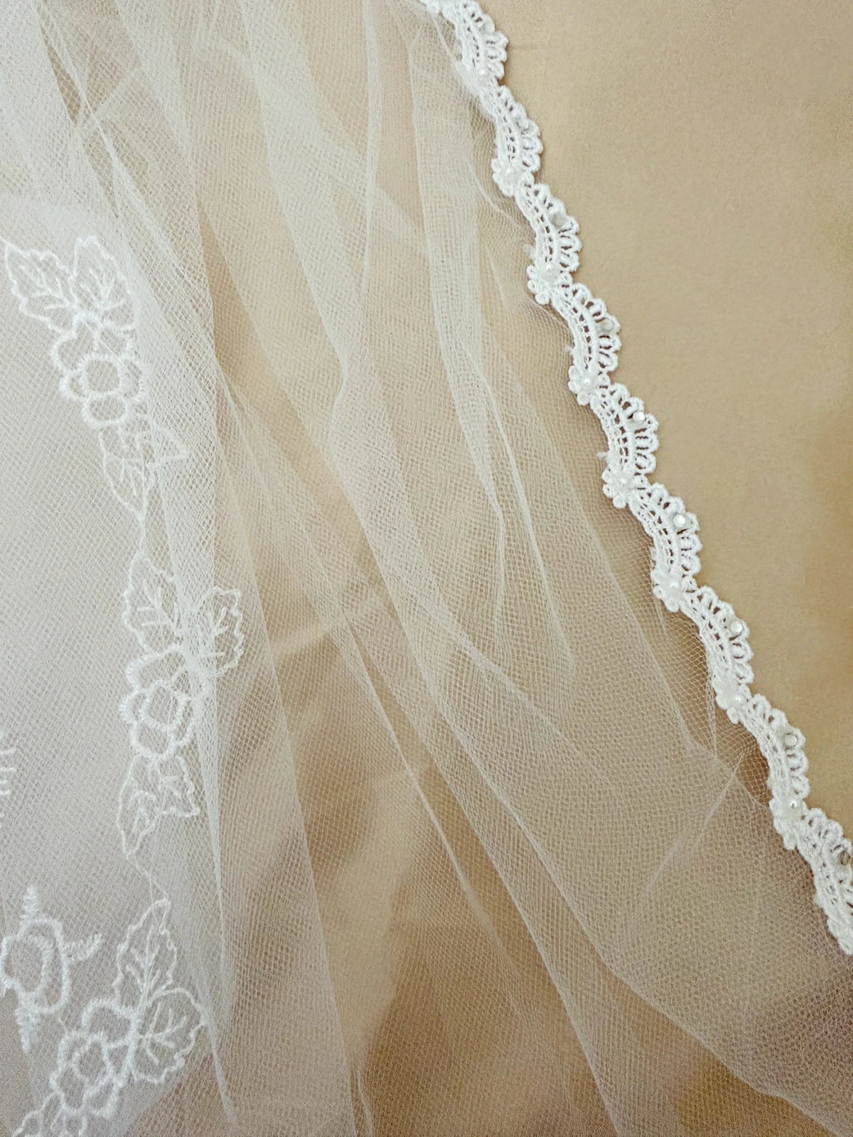 White pearl rhinestone lace Virgin Mary embroidered first communion veil, close-up, embellishment detail.