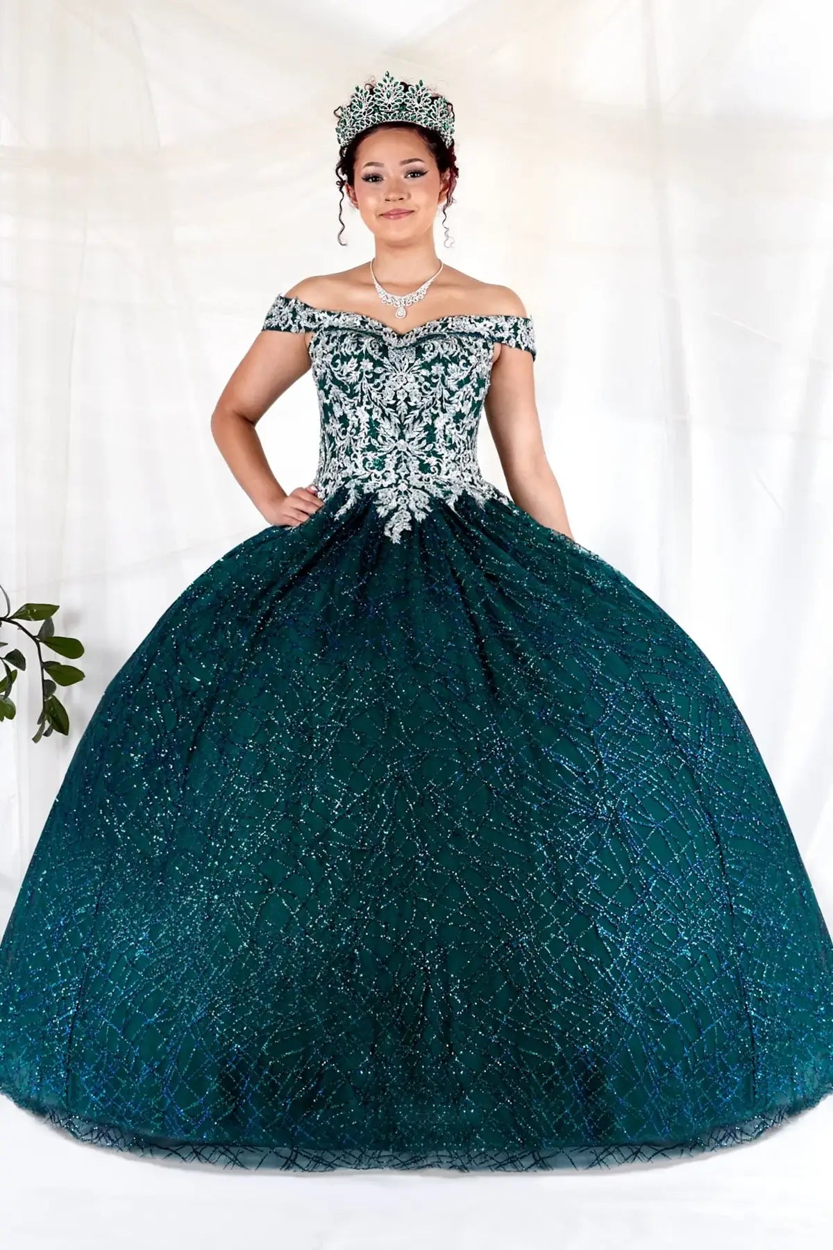 Front-Facing of a woman wearing Emerald green ball gown with sequin embellishments glitter tulle skirt and elegant structured bodice