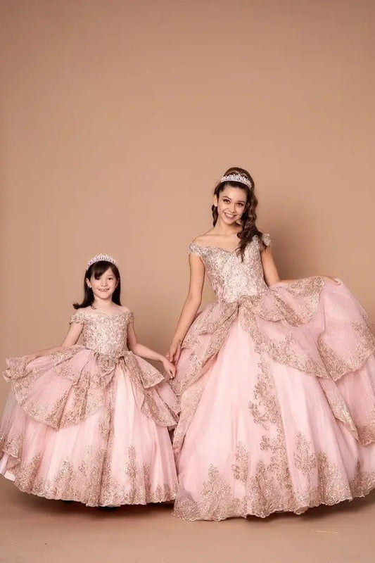 Front-Facing of a woman wearing Blush and gold quinceanera gown with off-shoulder sleeves intricate embroidery and voluminous layered skirt