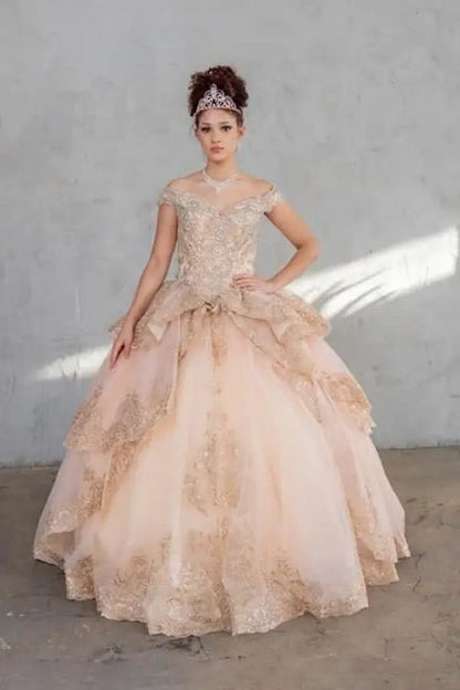 Front-Facing of a woman wearing Champagne and gold quinceanera gown with off-shoulder sleeves intricate embroidery and layered skirt design