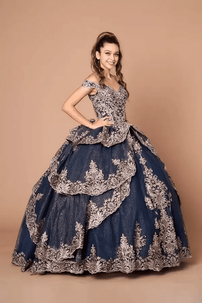 Front-Facing of a woman wearing Navy and gold quinceanera gown with off-shoulder sleeves intricate embroidery and layered skirt design