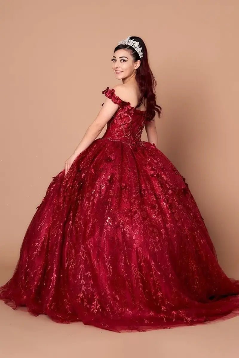 Side View of a woman wearing Deep red gown with floral accents off-shoulder styling and airy skirt design