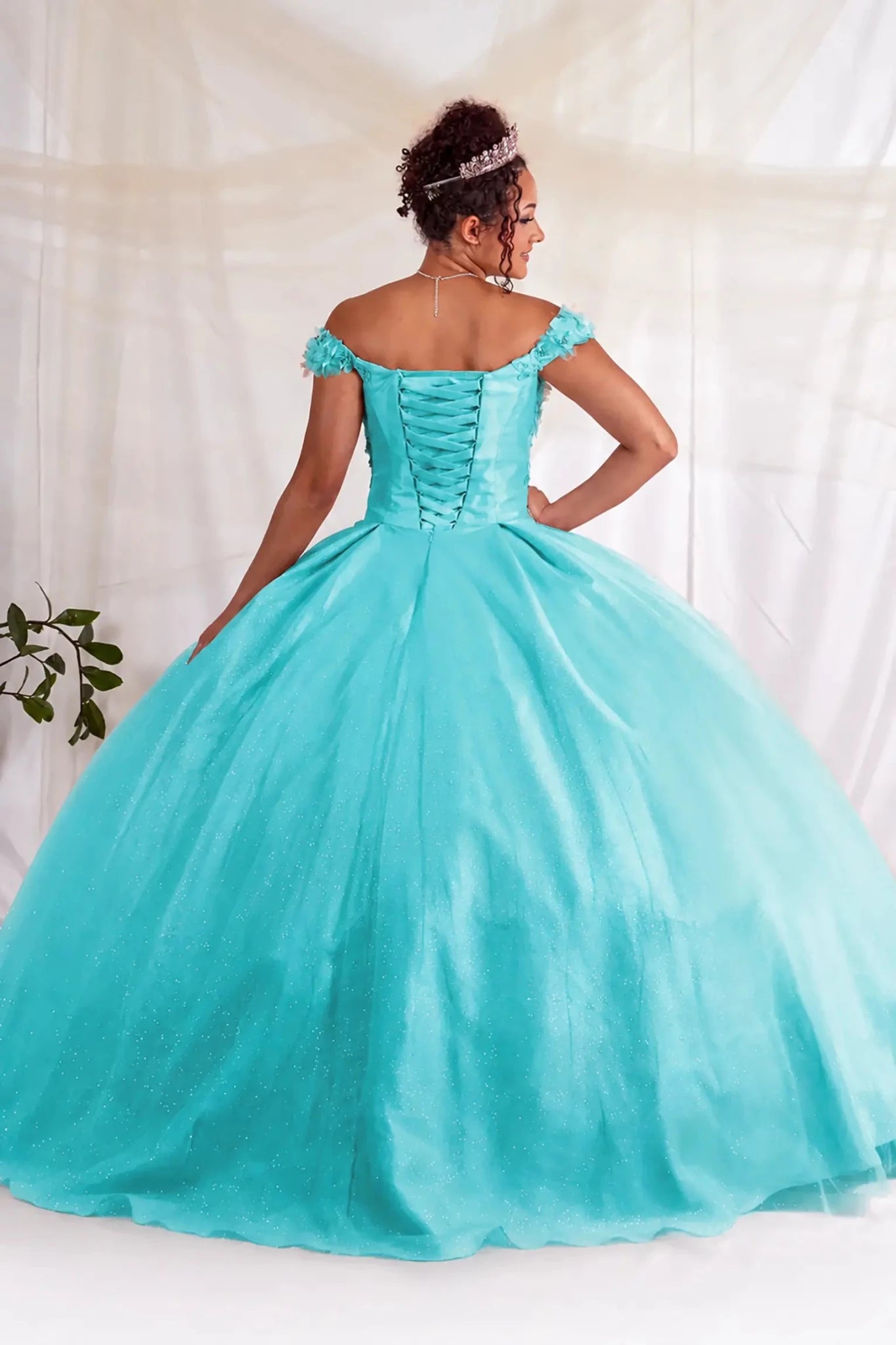 Woman in a mint quince ball gown with lace up back and off the shoulder 