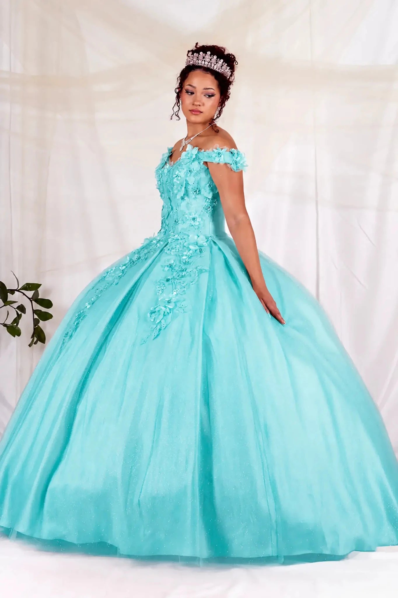 Woman in a aqua mint quinceanera  ball gown with floral details