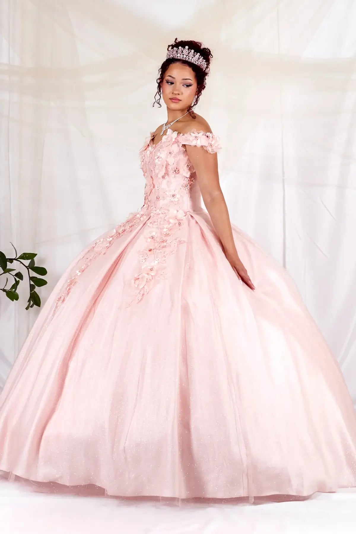 Side View of a woman wearing Soft pink gown with dimensional floral details sculpted bodice and flowing skirt shape