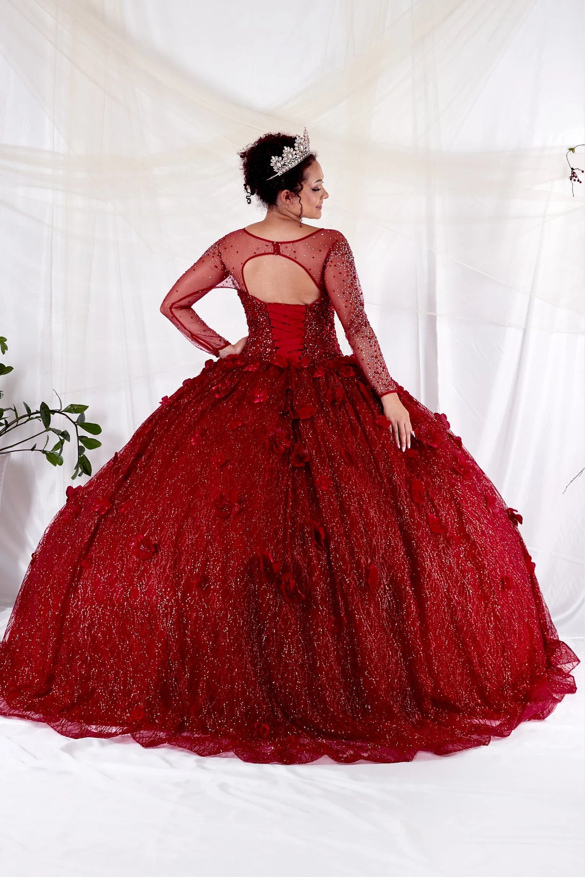 From behind, the Burgundy quinceañera ball gown reveals a fitted back and the dimensional finish of the skirt.