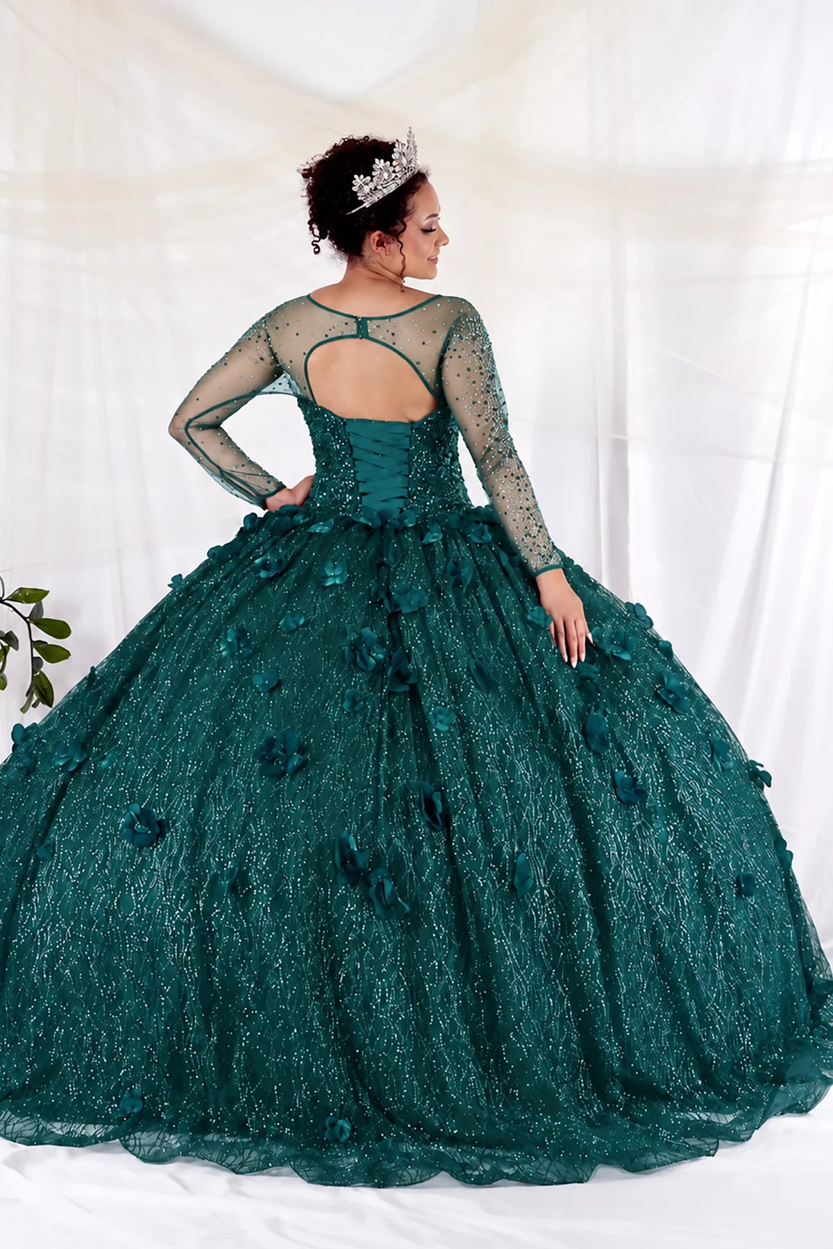From behind, the Emerald Green quinceañera ball gown reveals a fitted back and the dimensional finish of the skirt.