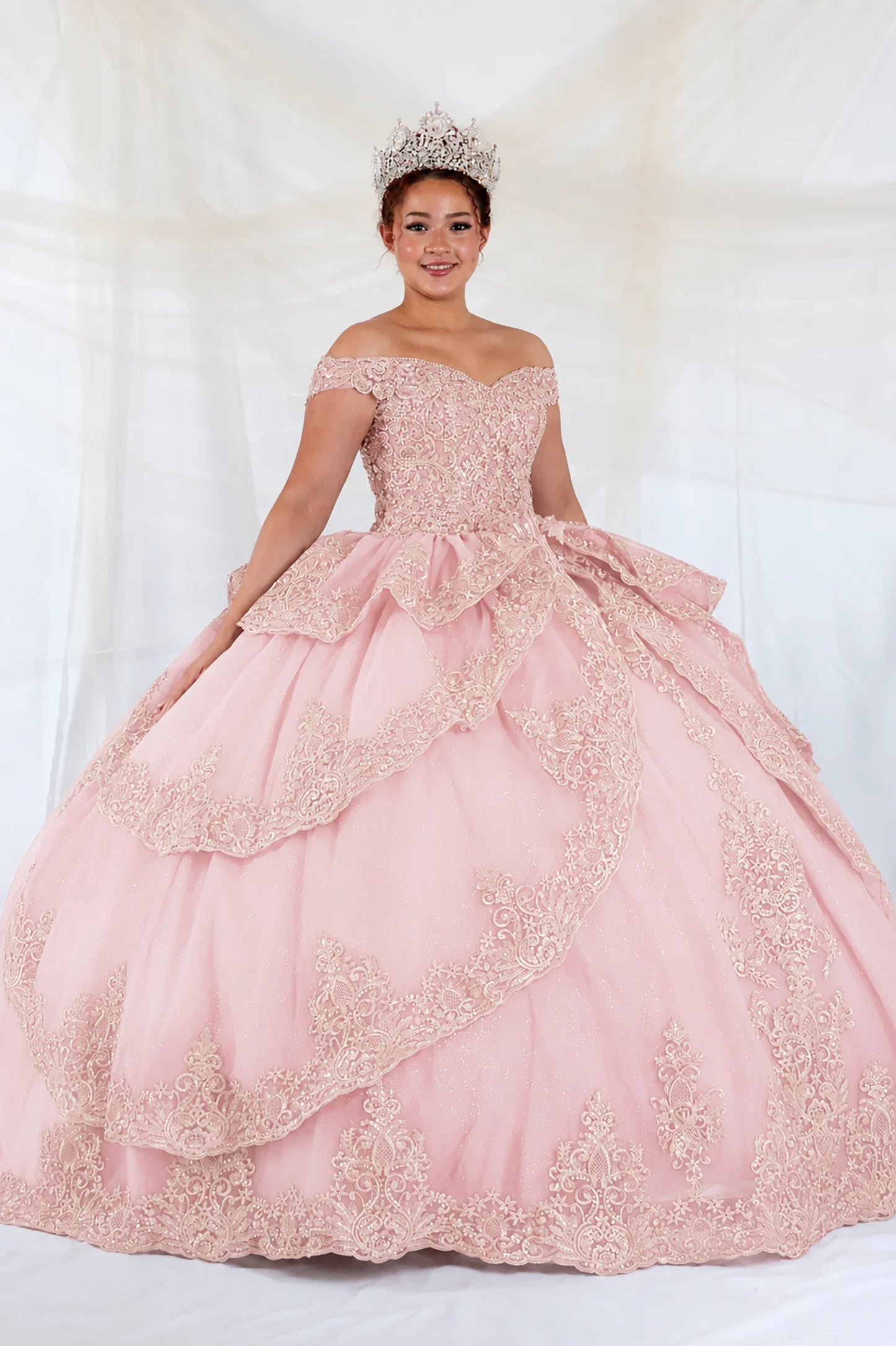 off-the-shoulder light pink quuinceanera ball gown with intricate lace applique and a tiered ruffled skirt